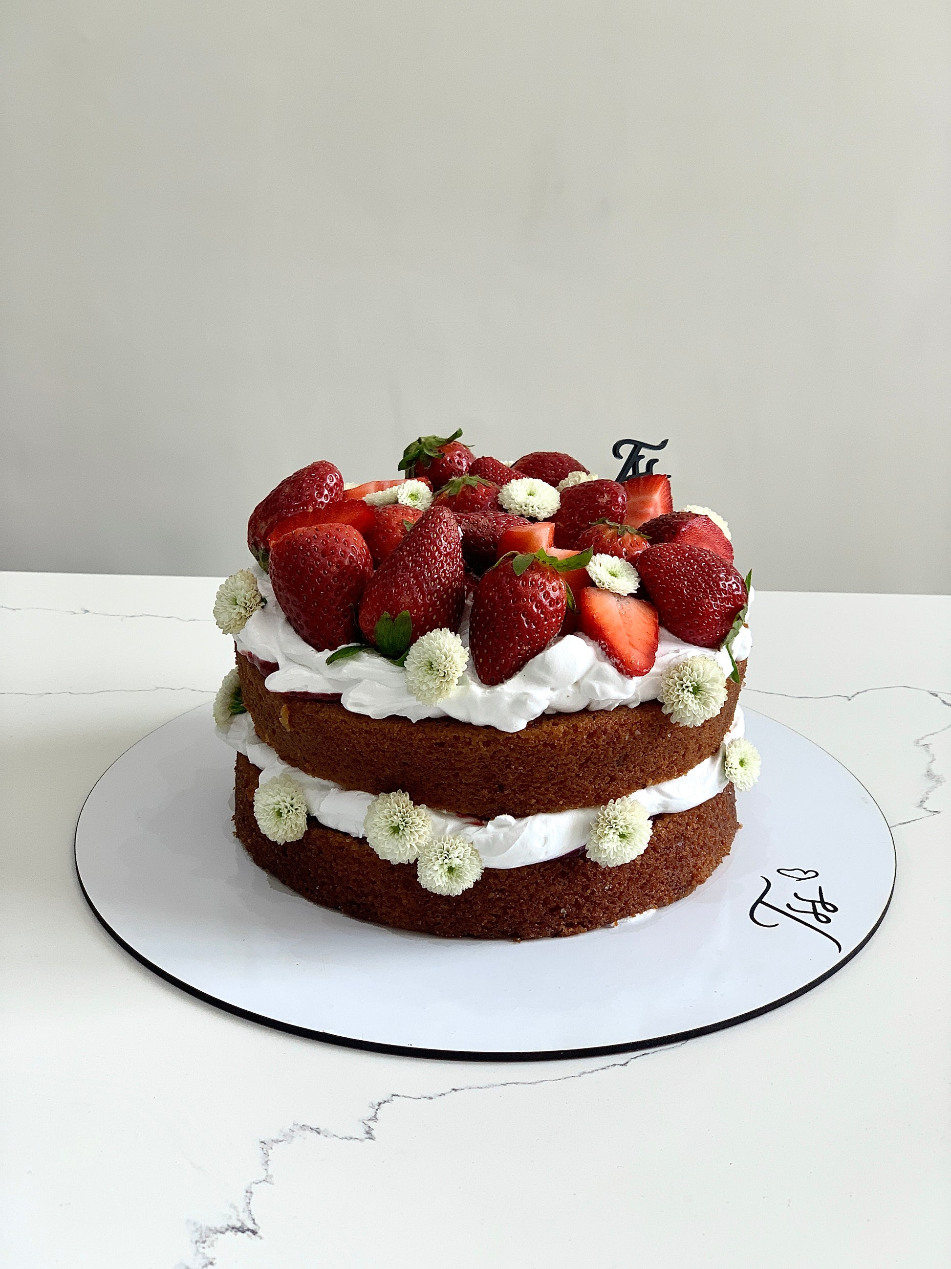 Fresh fruit cake from The Sinful Spoon with colorful fruit toppings and moist texture, perfect for dessert or celebration.