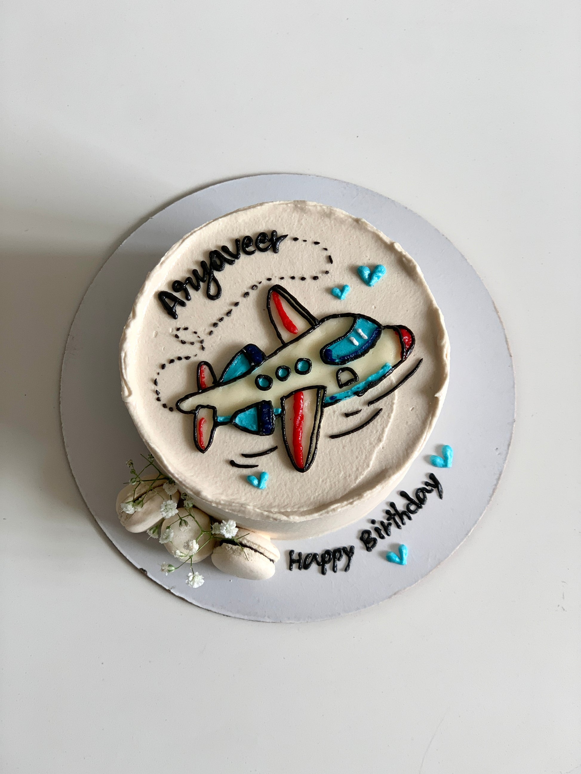 Decorative buttercream illustration cake by The Sinful Spoon featuring colorful floral and whimsical designs on a layered cake.