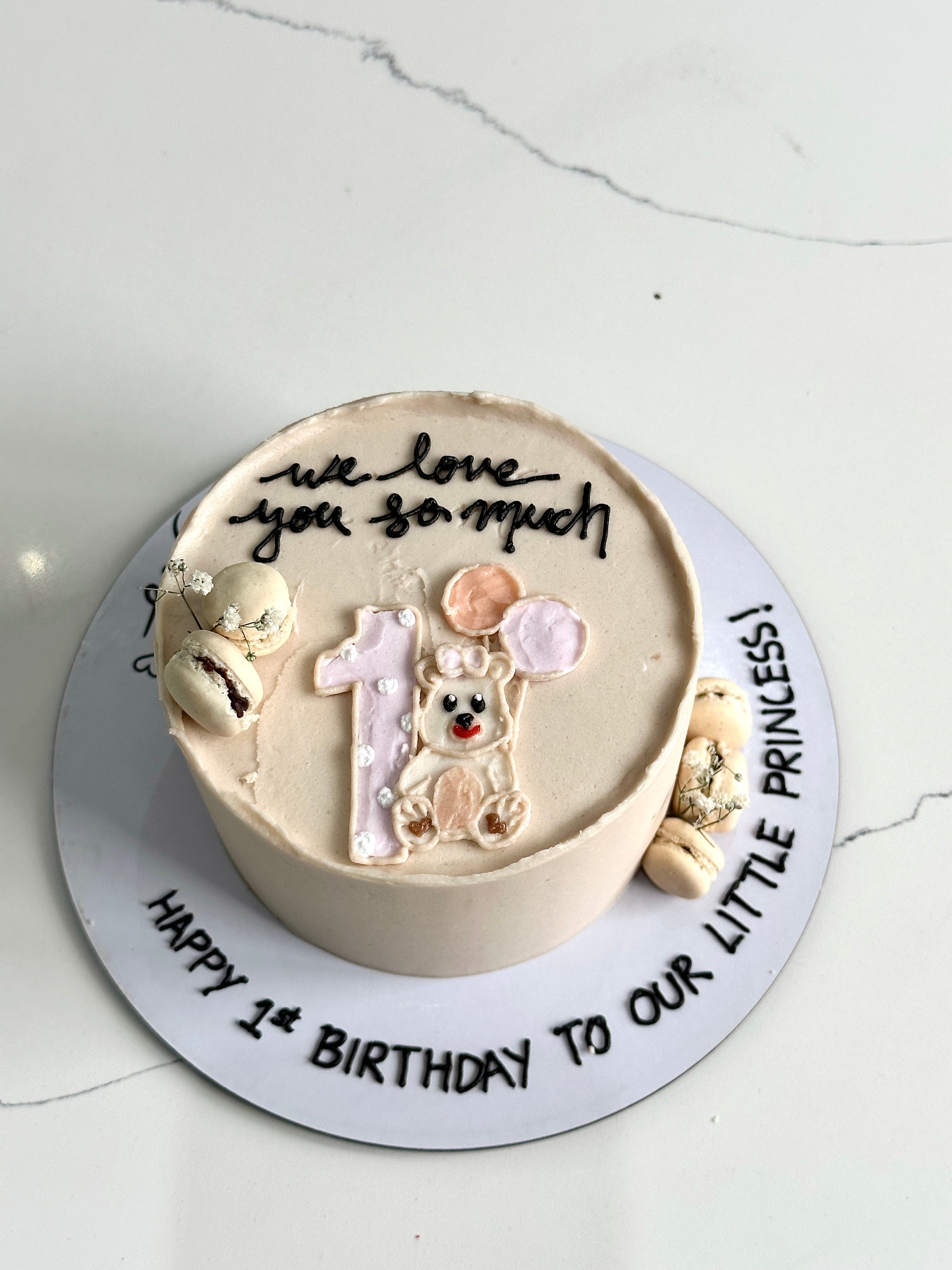Decorative baby shower cake from The Sinful Spoon featuring pastel colors and adorable baby-themed decorations.