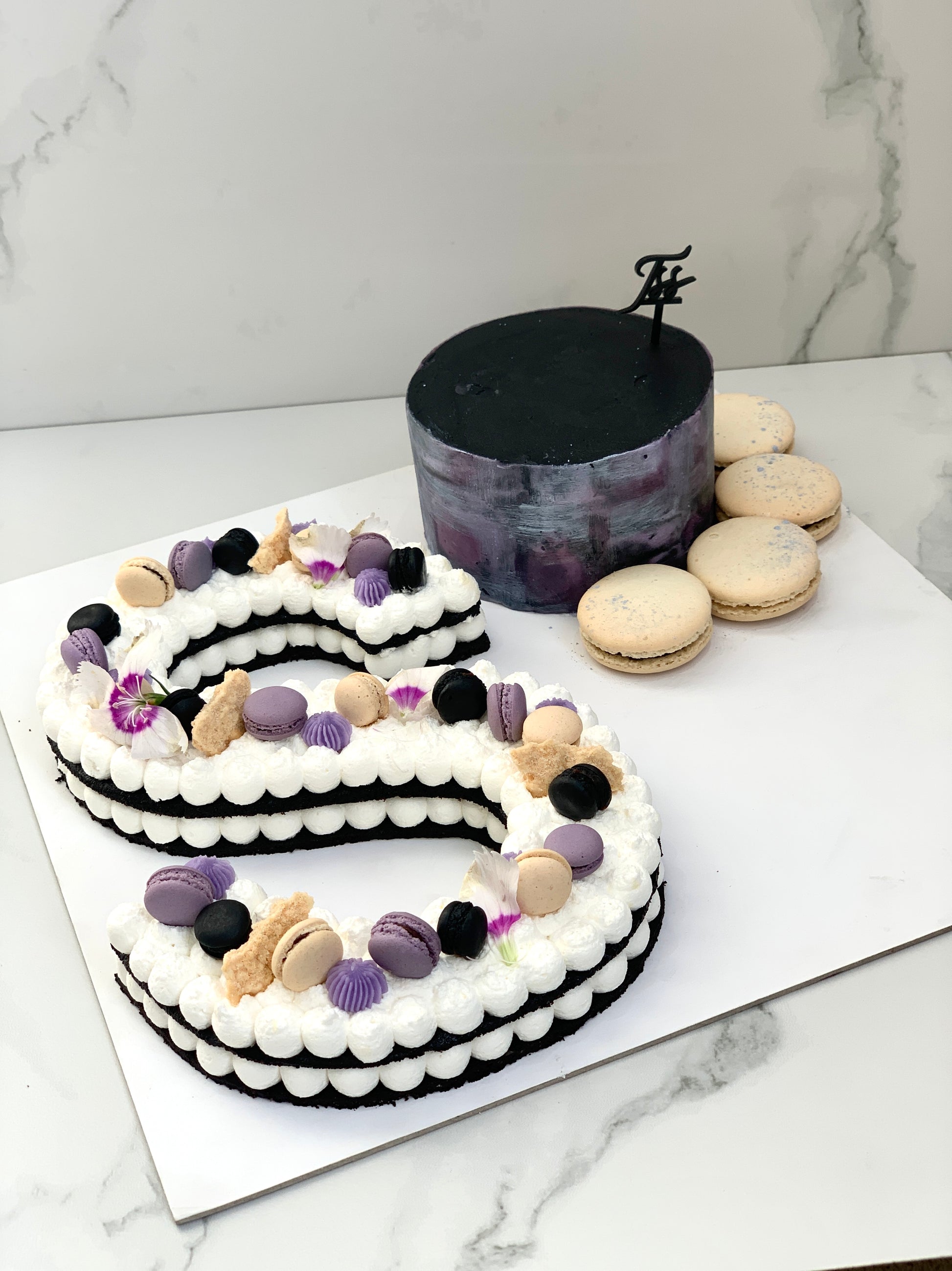 Assorted combo cakes from The Sinful Spoon featuring layered desserts with colorful frosting and decorative toppings.