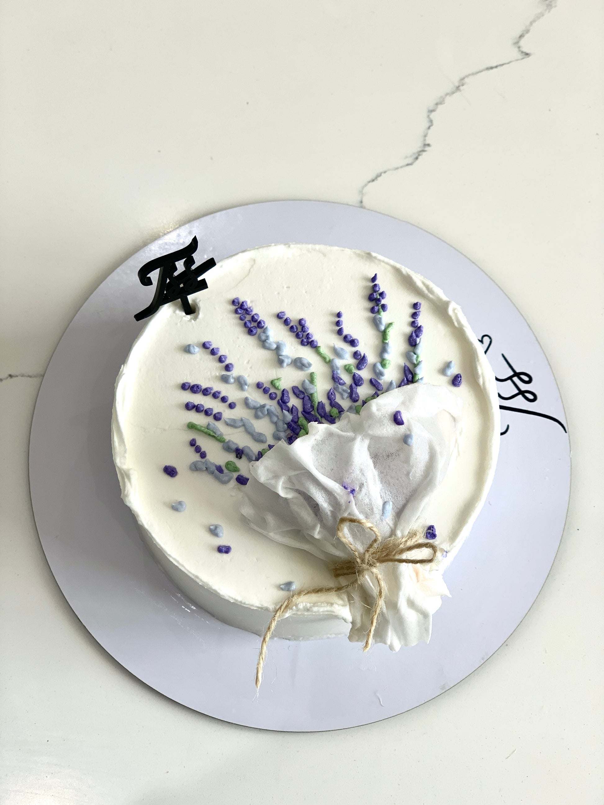 Decorative Mother's Day cake from The Sinful Spoon with floral icing and colorful toppings, perfect for celebrating moms.