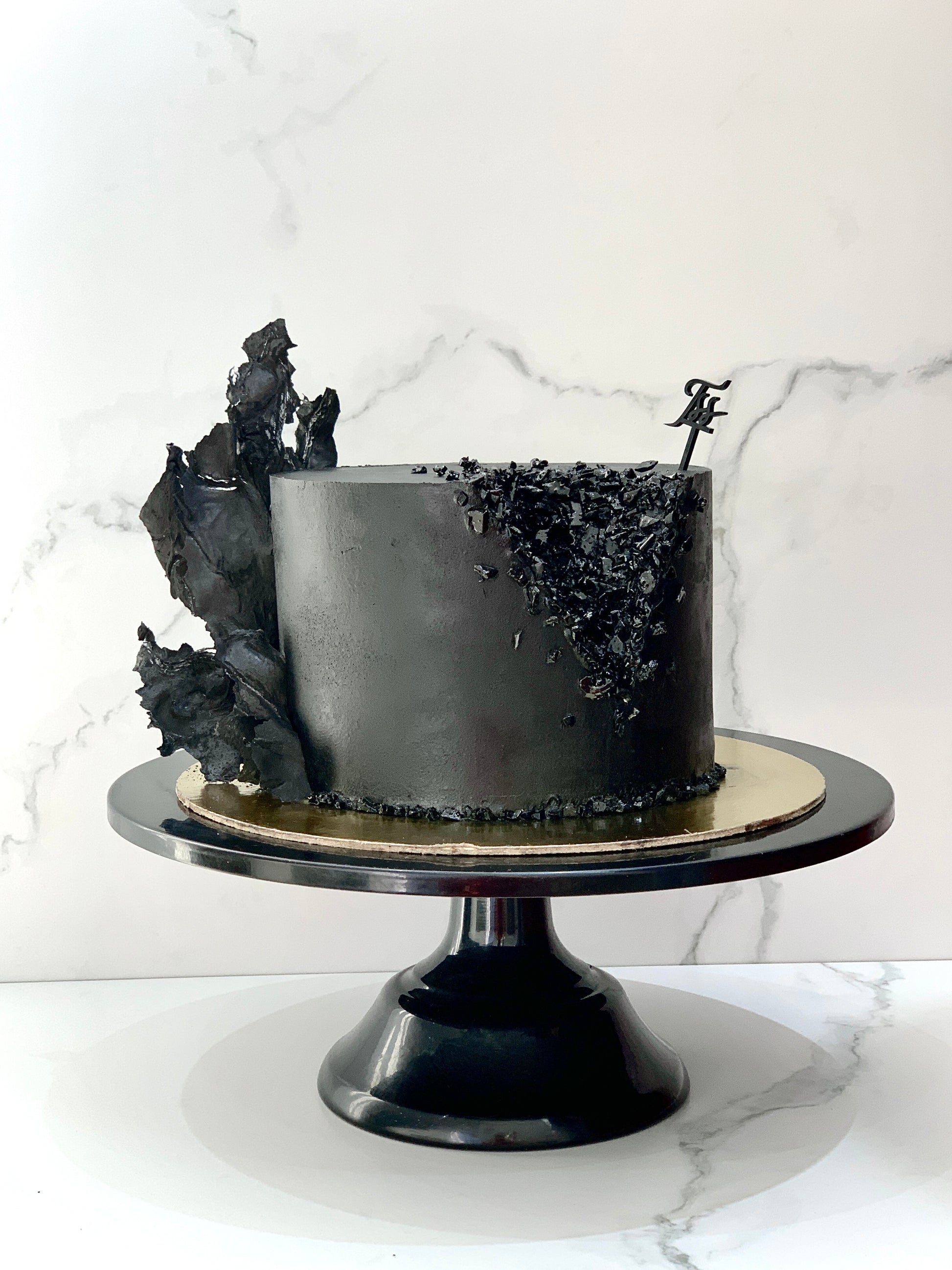Classic cakes from The Sinful Spoon with layered frosting and decorative toppings on a white plate.
