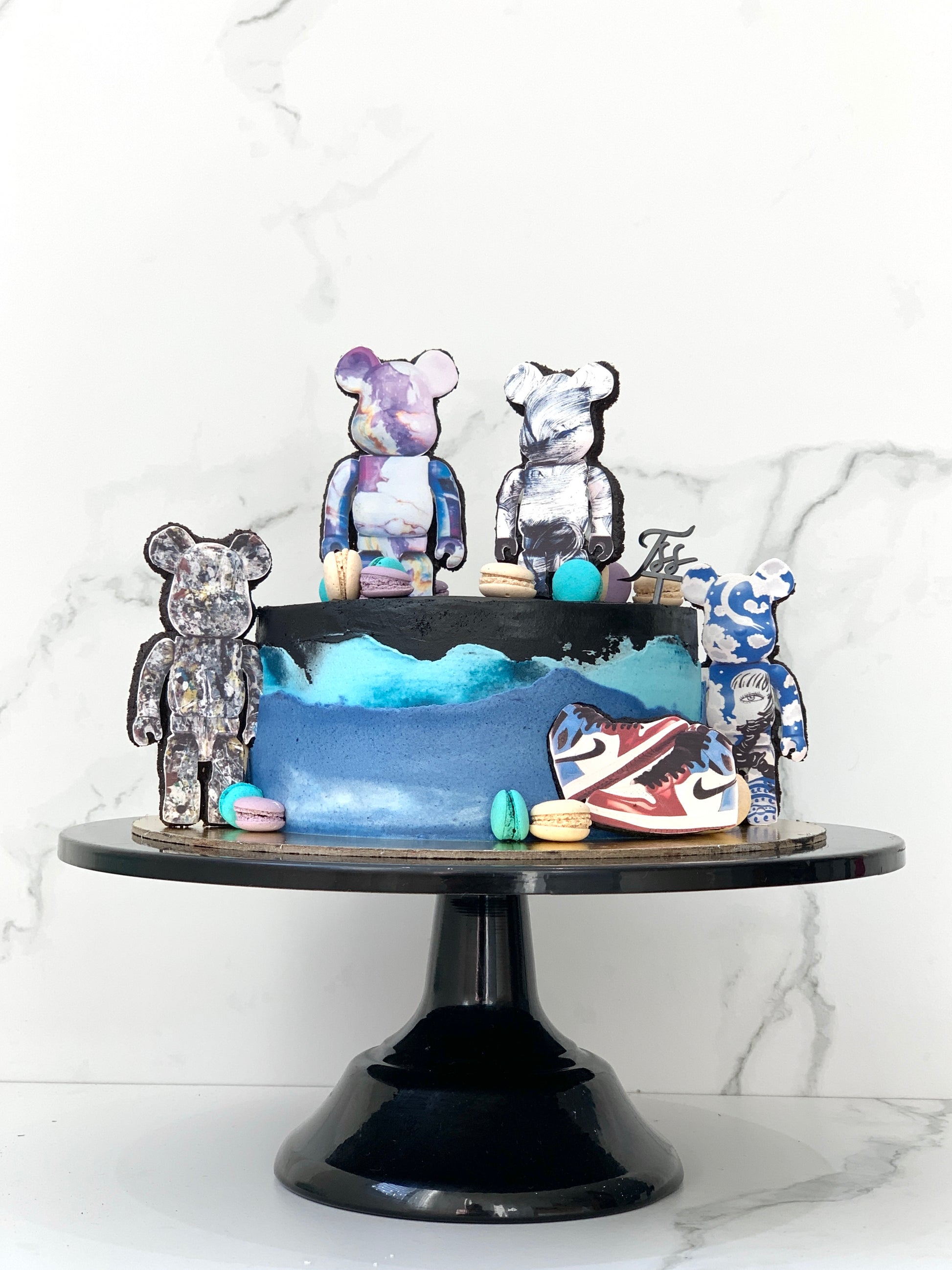 Edible paper cakes from The Sinful Spoon featuring colorful, decorative cake designs on a white background.