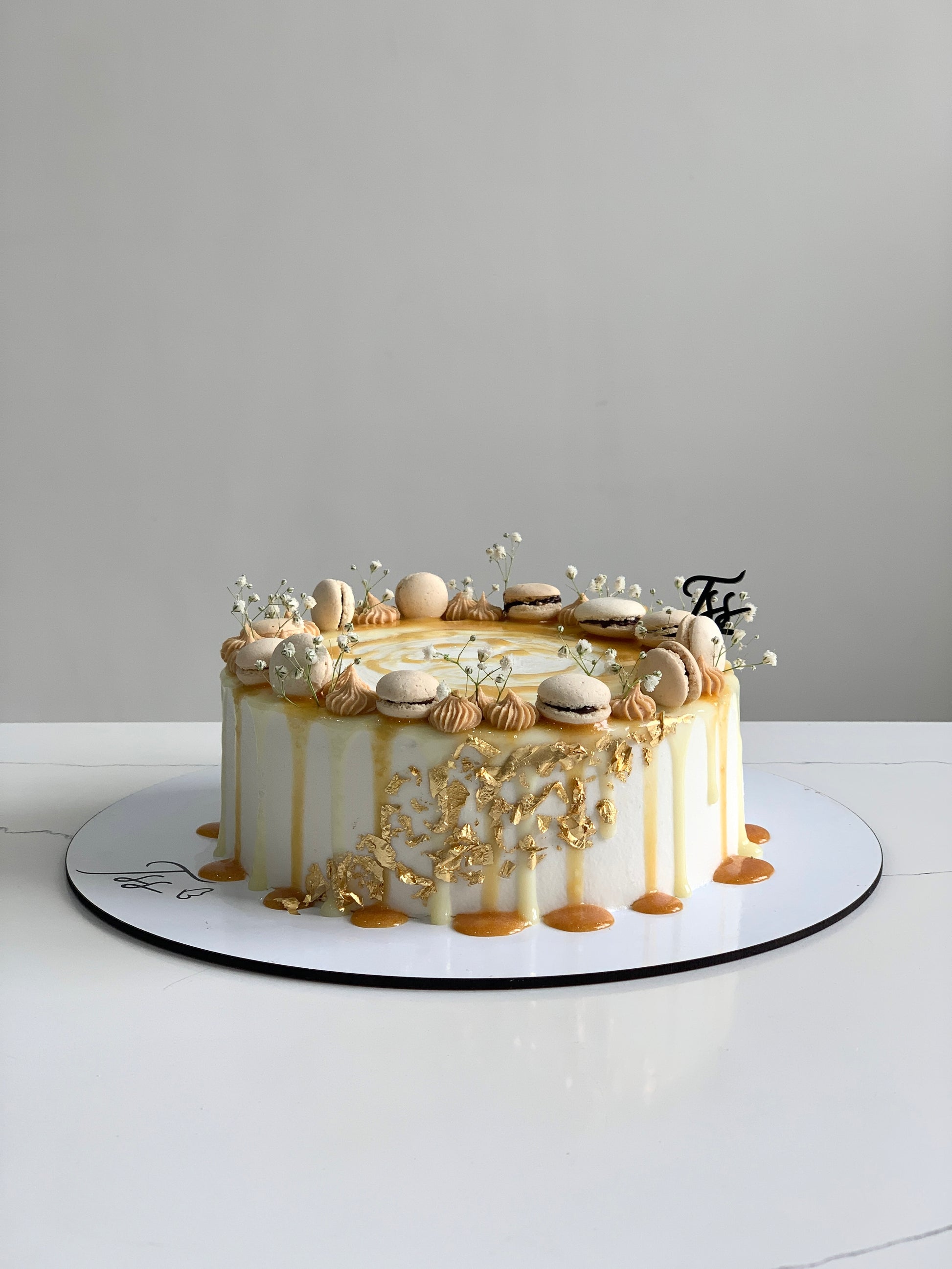 Slice of classic cake from The Sinful Spoon with rich frosting and colorful sprinkles on a white plate.