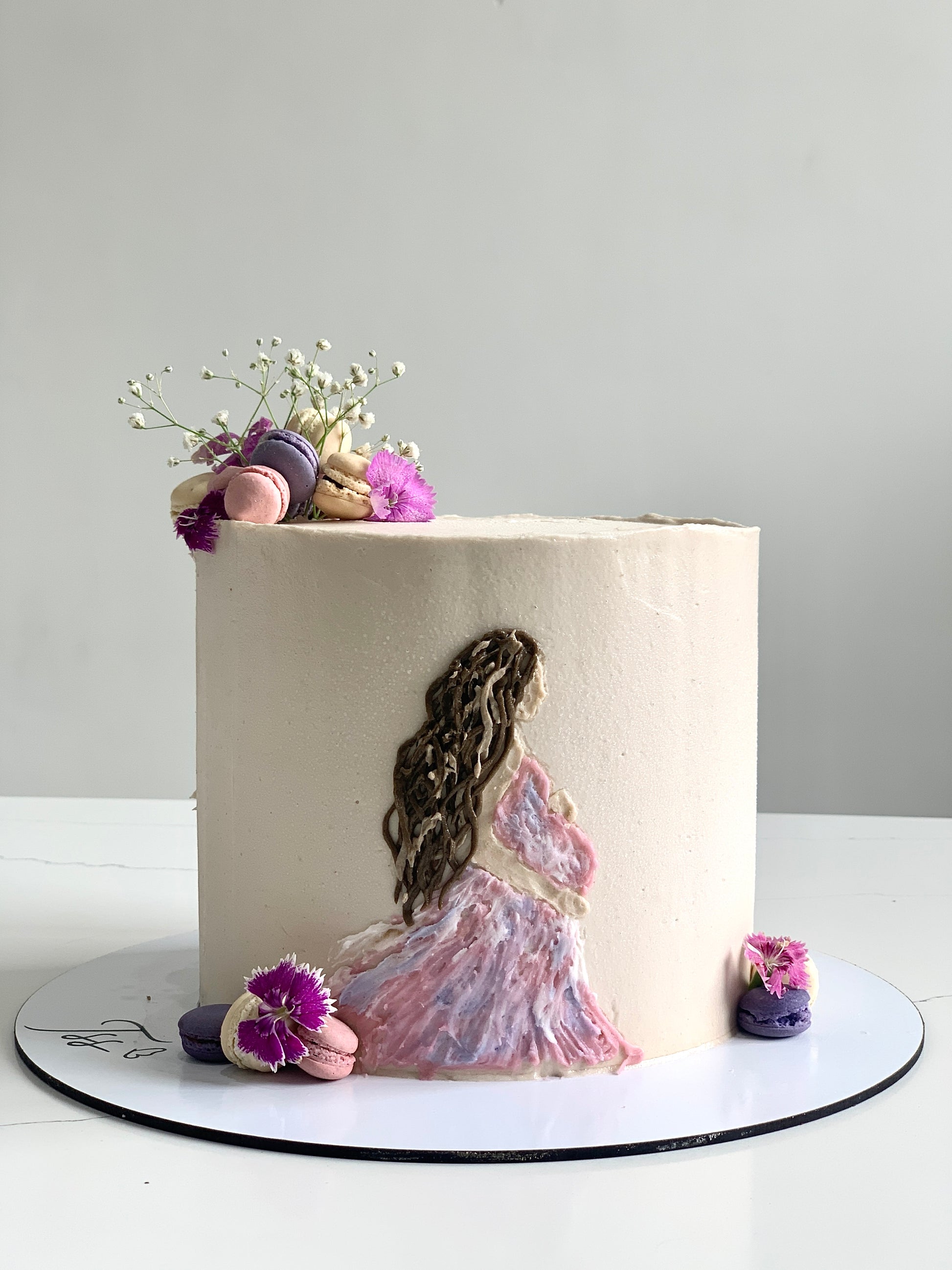 Decorative baby shower cake with pastel frosting and baby-themed toppers from The Sinful Spoon.