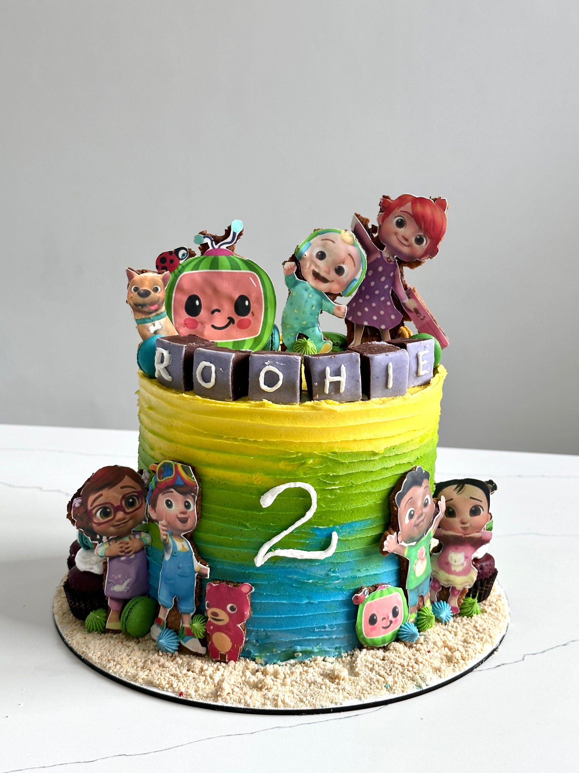 Edible paper cake with baby boy design from The Sinful Spoon, decorated with colorful icing and edible decorations for celebration.