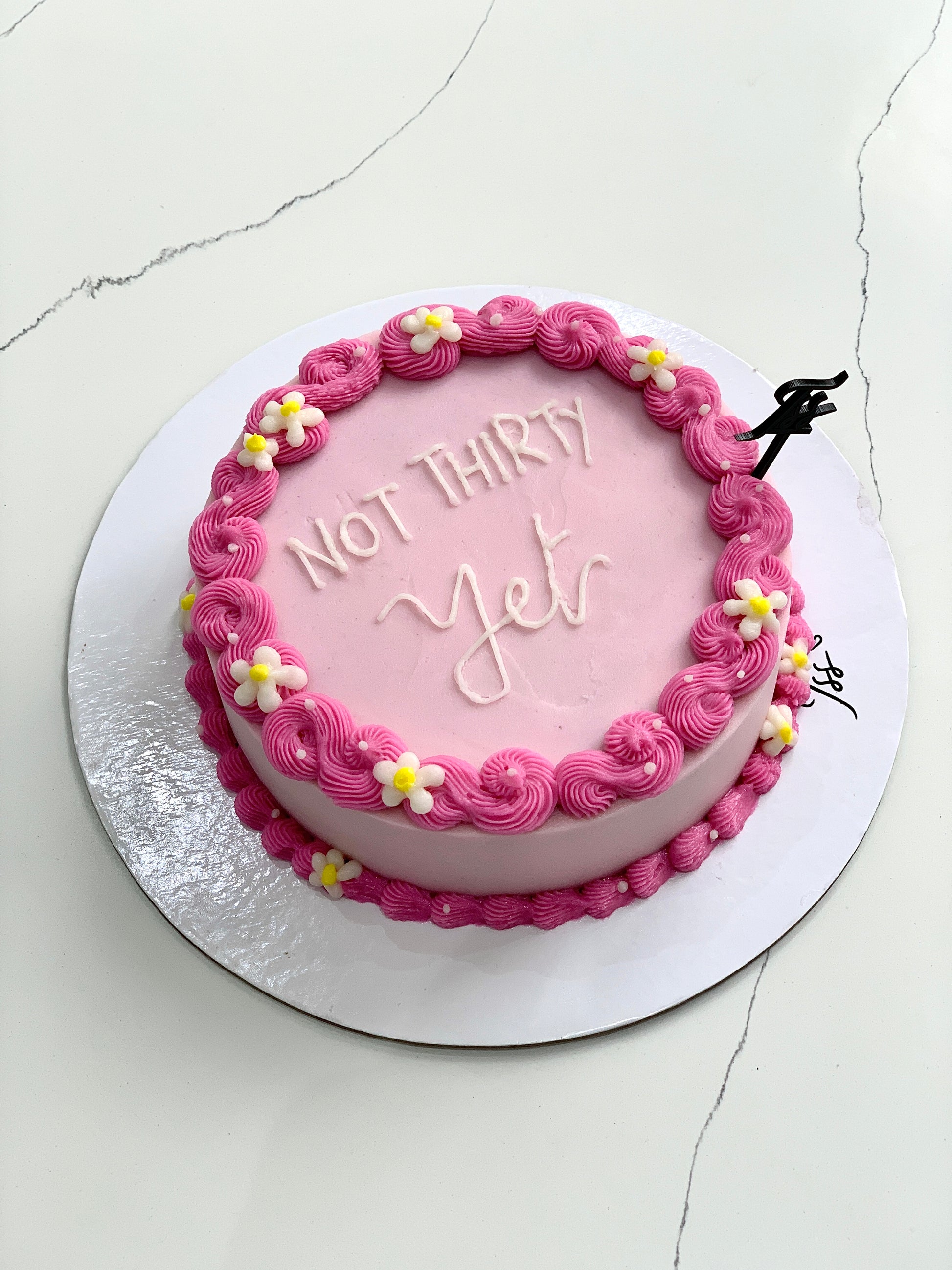 Decorative buttercream flower cakes by The Sinful Spoon with intricate floral designs on a white background.