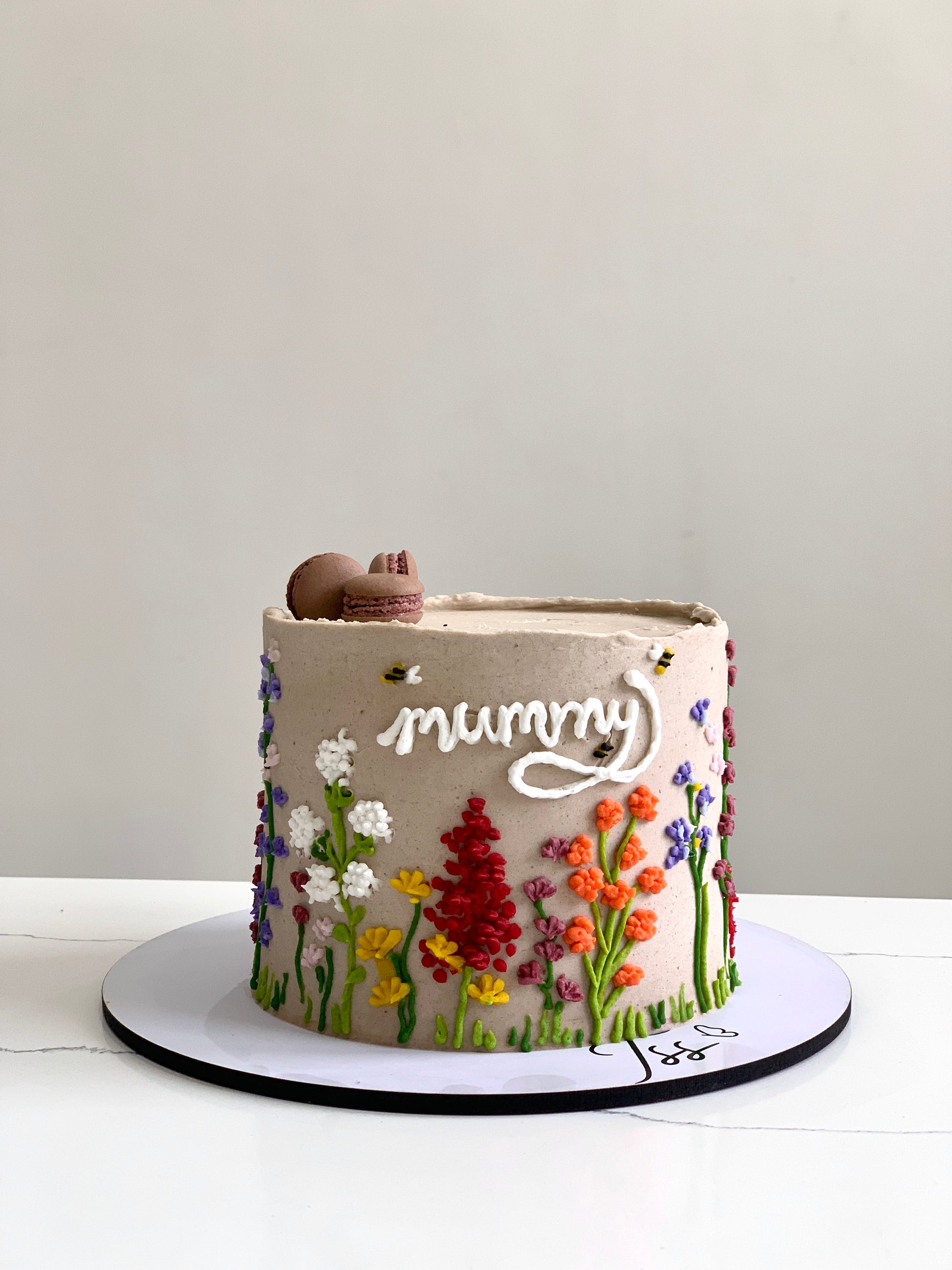 Decorative Mother's Day cakes from The Sinful Spoon with floral designs and colorful frosting, perfect for celebrating moms.