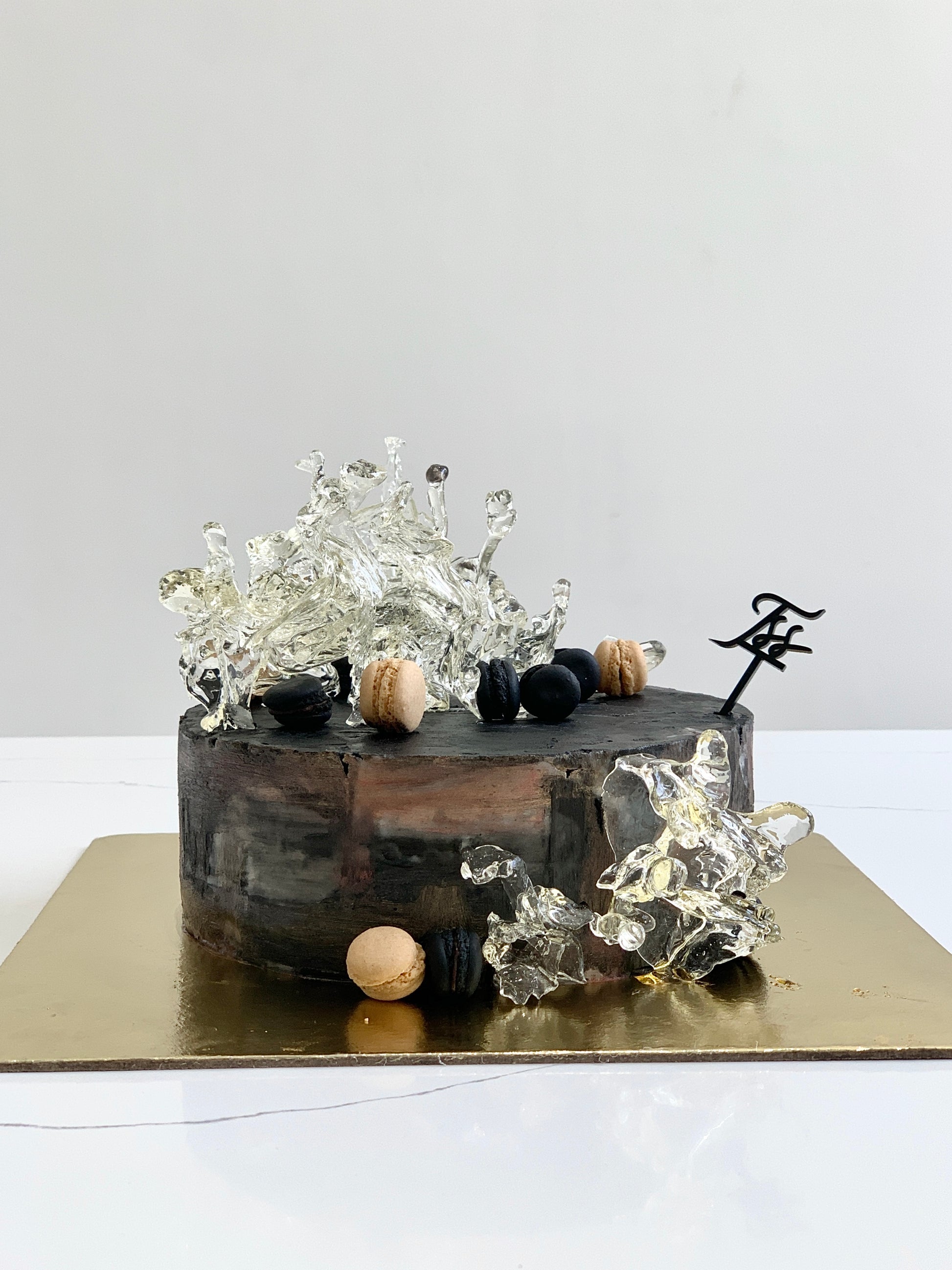 Isomalt cakes by The Sinful Spoon shown in a close-up, featuring clear, glossy sugar molds ideal for cake decorating and sugar art.