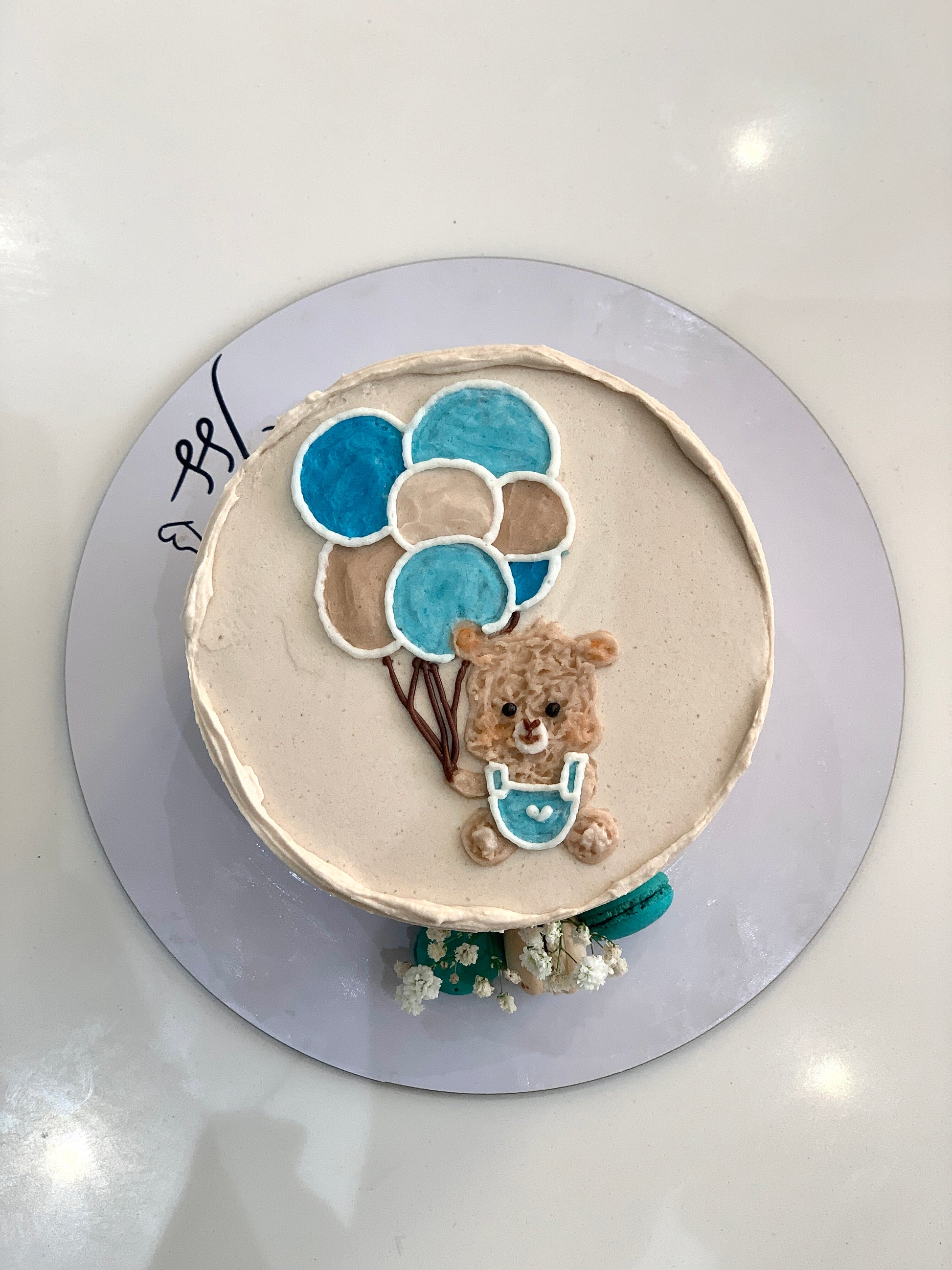 Decorative baby shower cake from The Sinful Spoon with pastel frosting and adorable baby-themed decorations.
