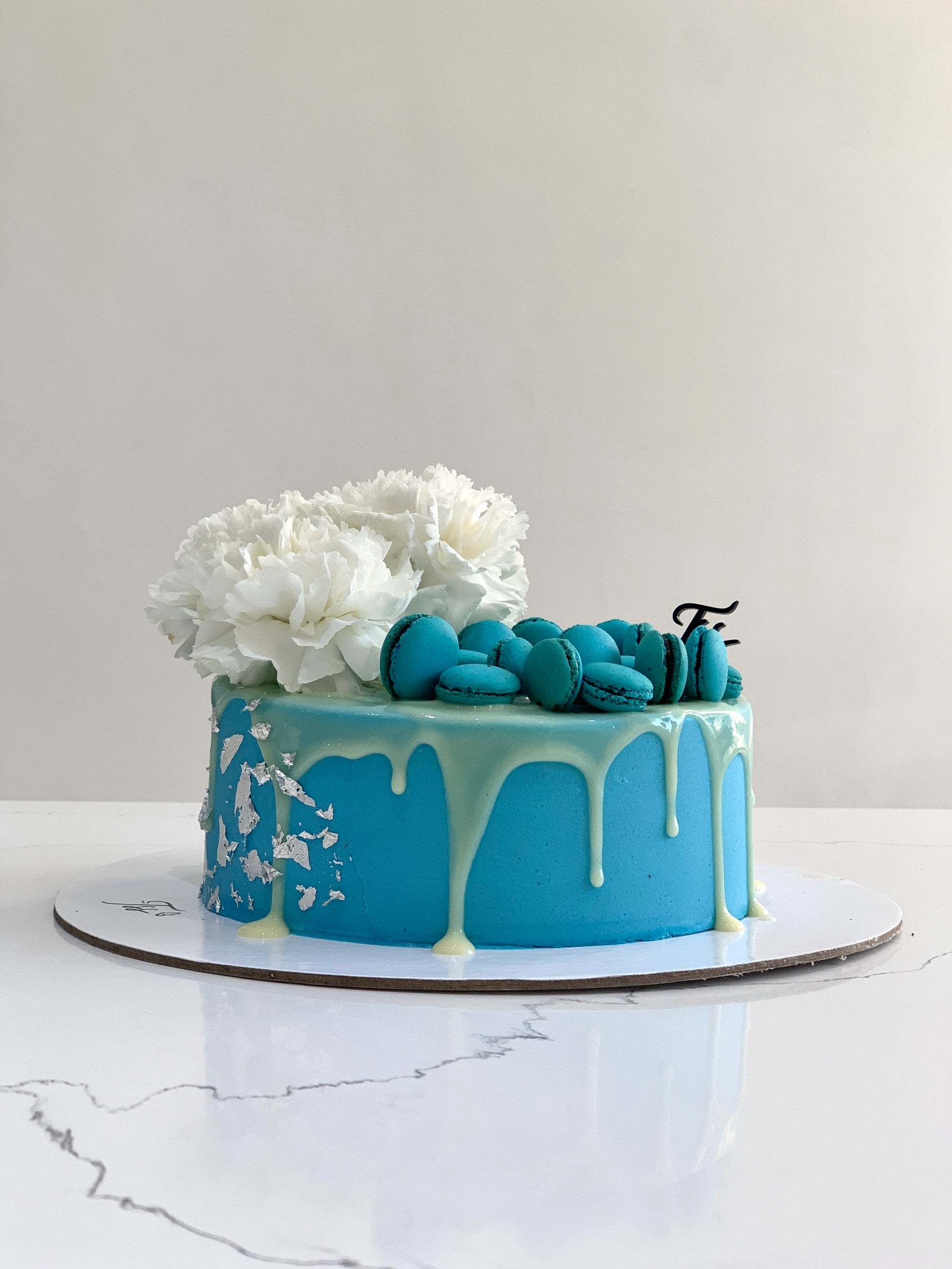 Fresh floral cakes from The Sinful Spoon featuring colorful frosting and decorative edible flowers on top.