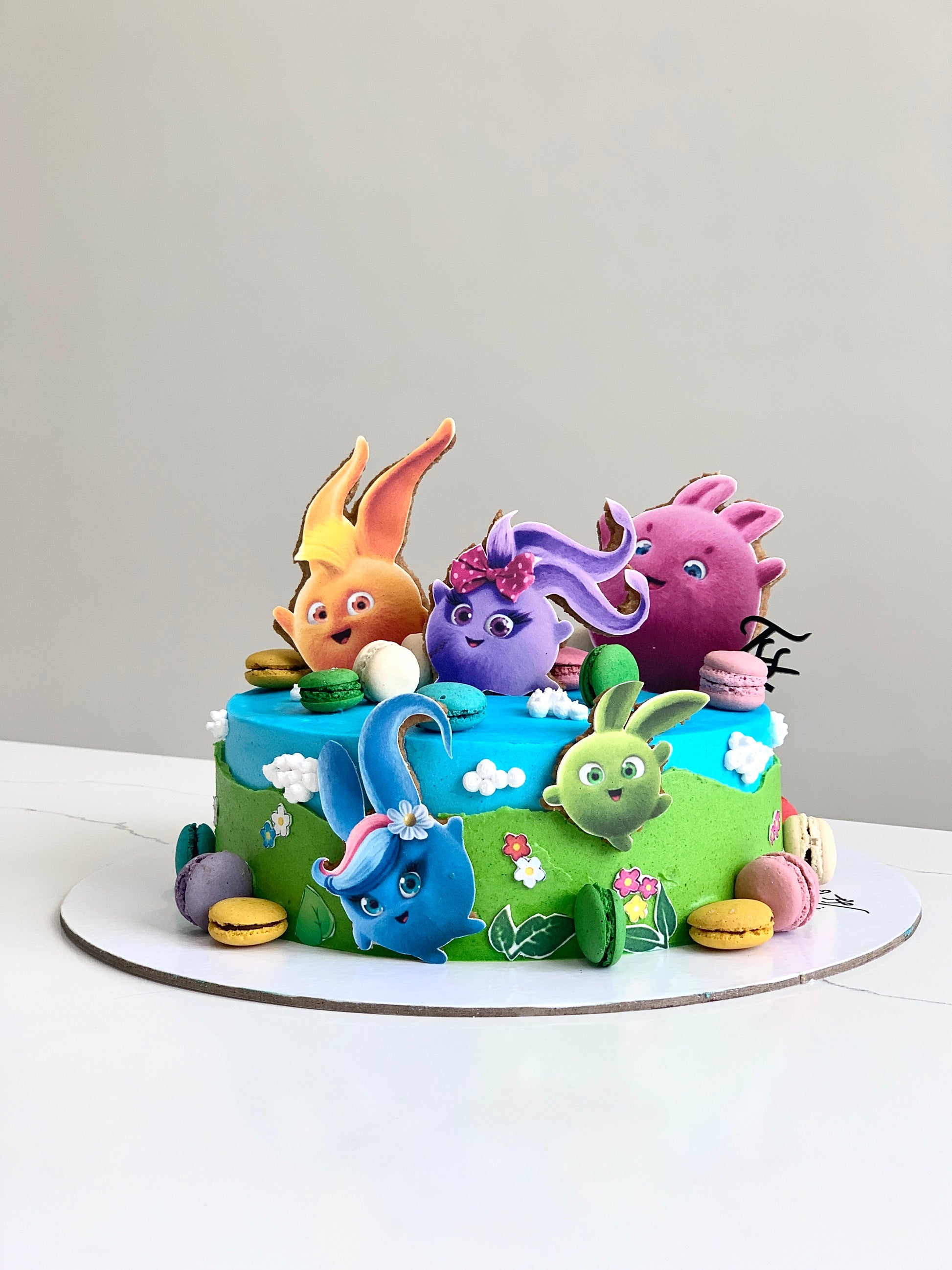 Edible paper cake featuring a baby girl design from The Sinful Spoon, decorated with colorful icing and intricate edible artwork.