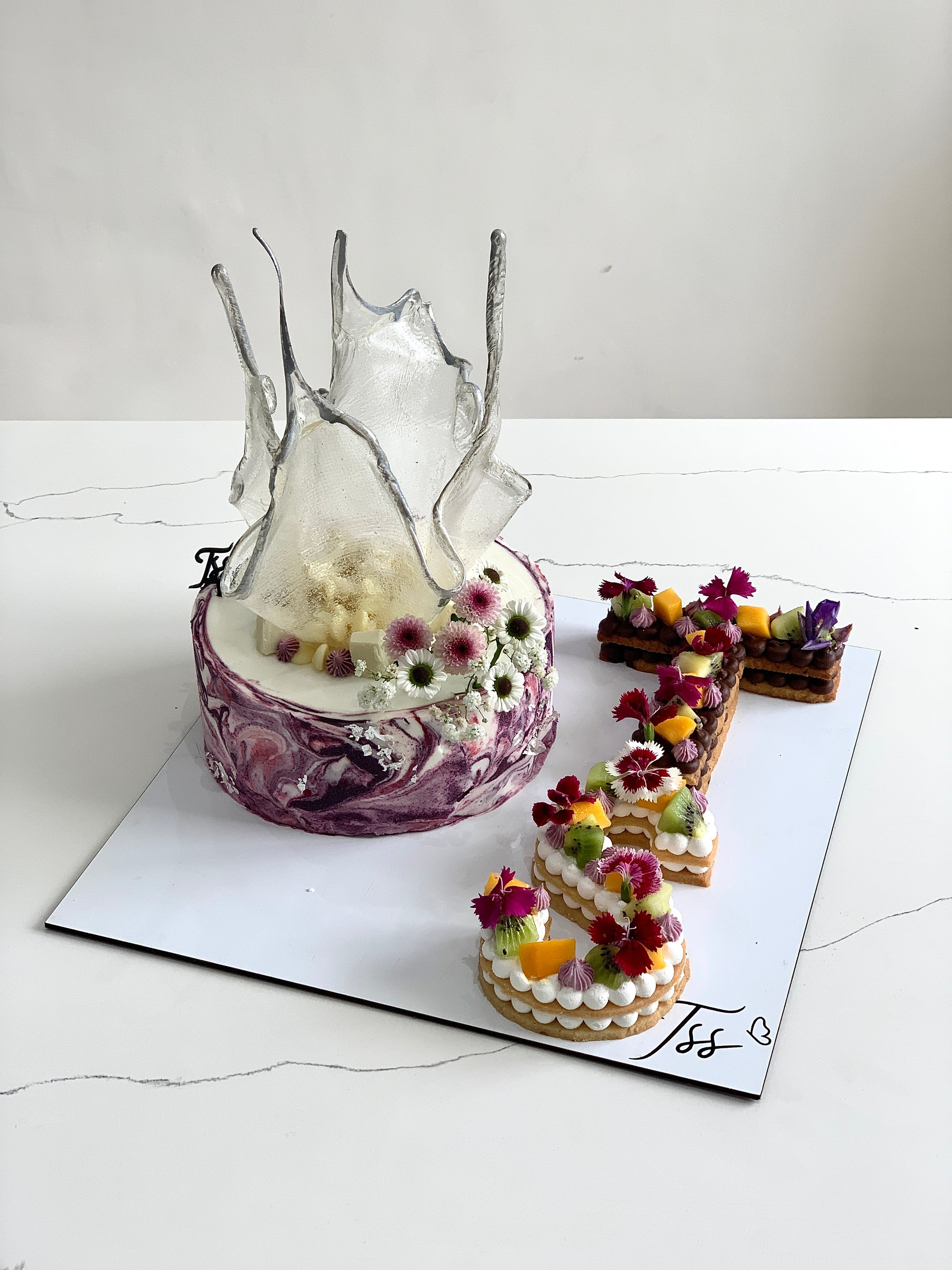 Assorted combo cakes from The Sinful Spoon featuring layered and decorated cakes displayed on a table.