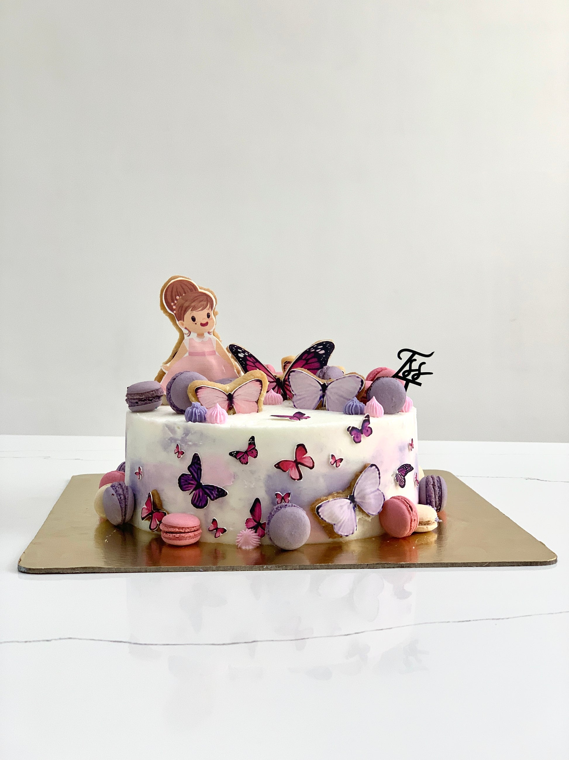 Edible paper cake decorated for a baby girl celebration, featuring pink and white design with baby-themed details by The Sinful Spoon.