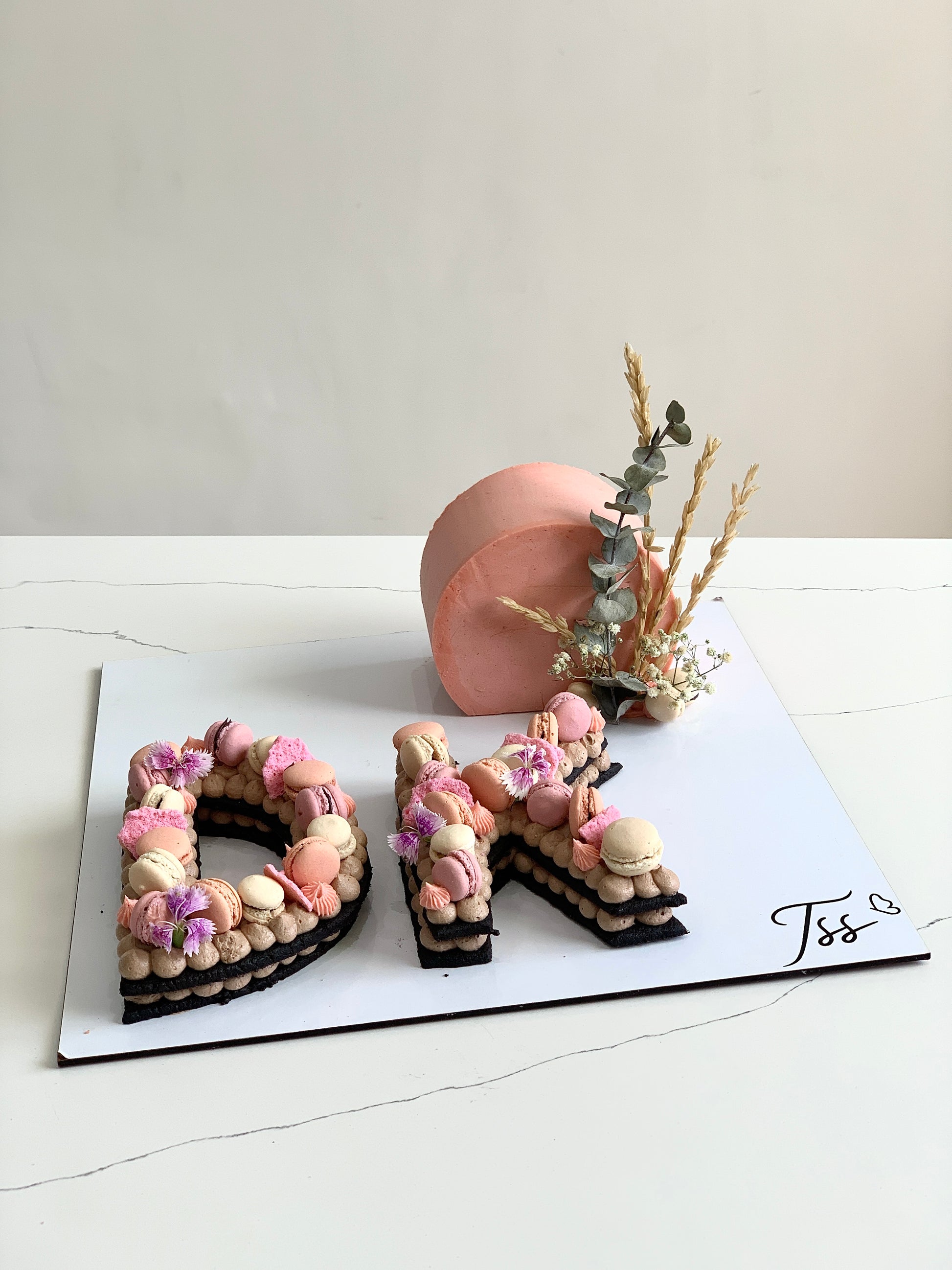Assorted combo cakes from The Sinful Spoon, featuring colorful layers and decorative frosting on a white plate.