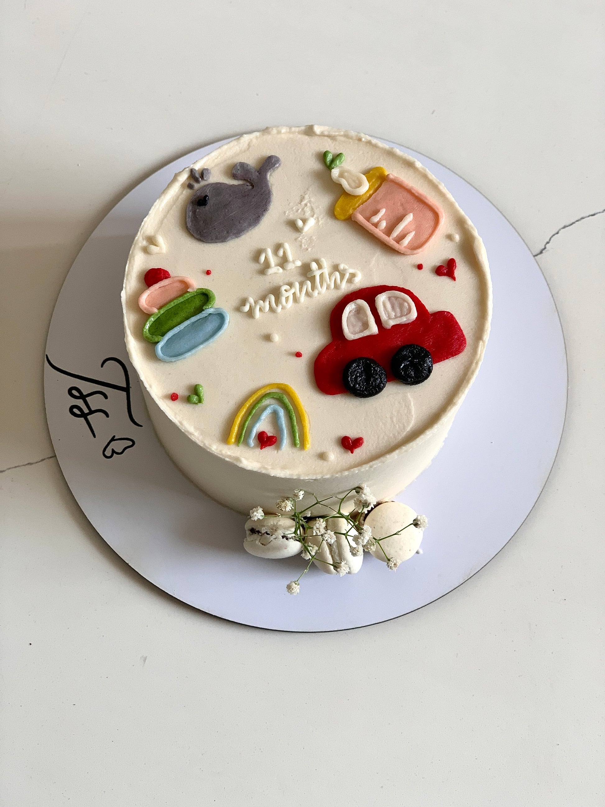 Decorative buttercream illustration cake by The Sinful Spoon with colorful floral and artistic piped designs on a white background
