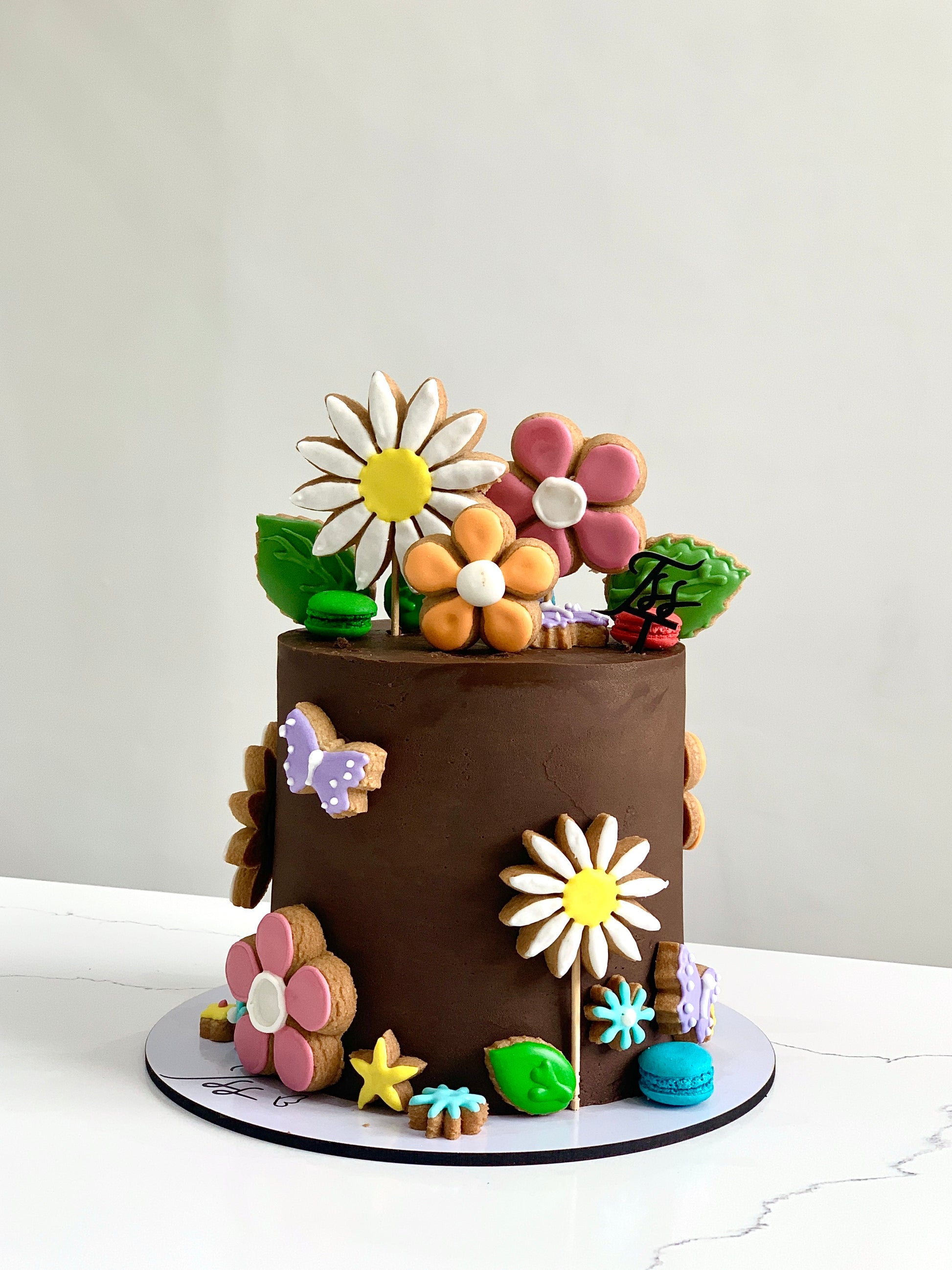 Decorative buttercream flower cakes by The Sinful Spoon, featuring colorful floral designs and intricate piping details.
