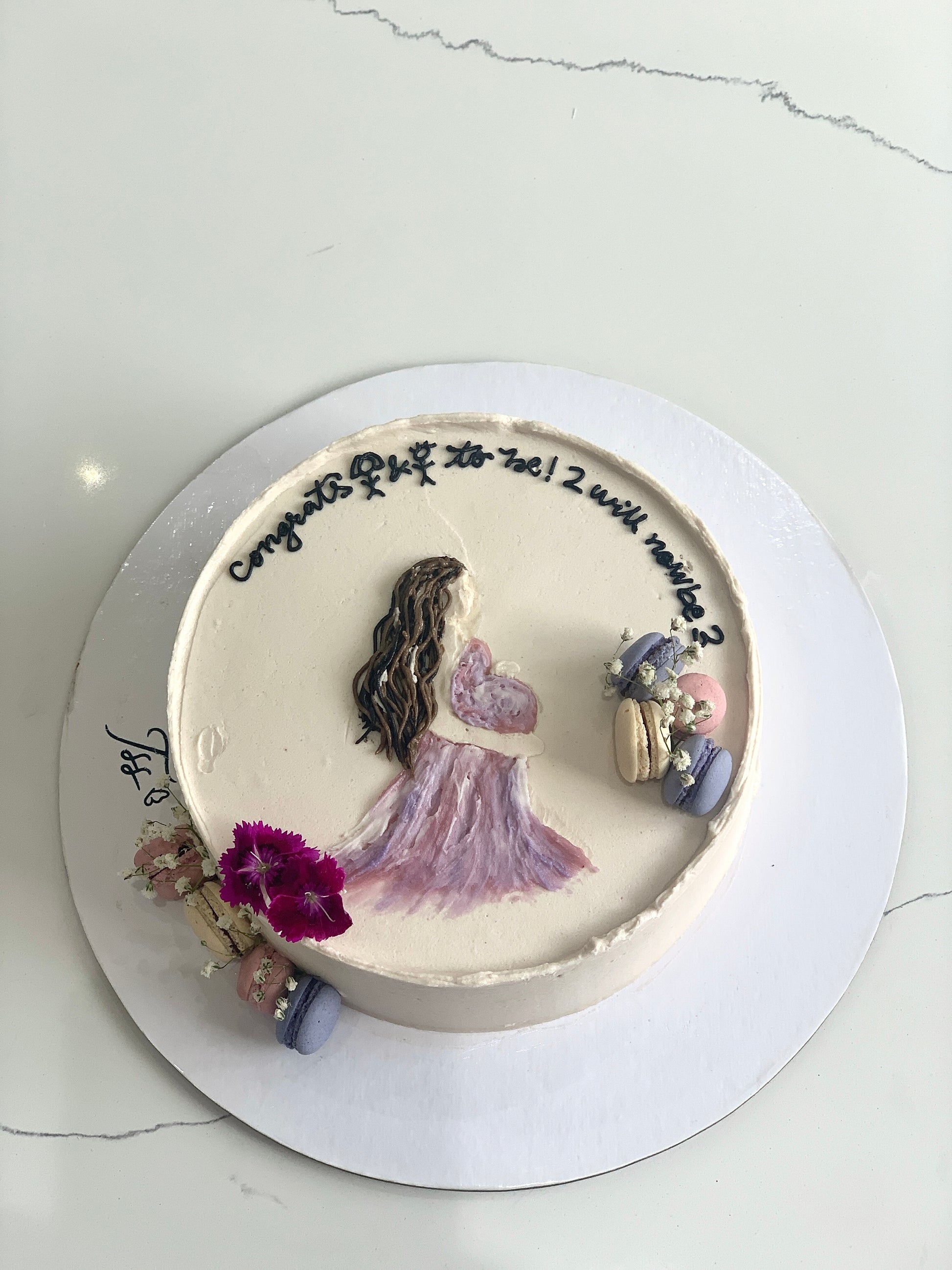 Decorative baby shower cake with pastel frosting and baby-themed decorations by The Sinful Spoon.