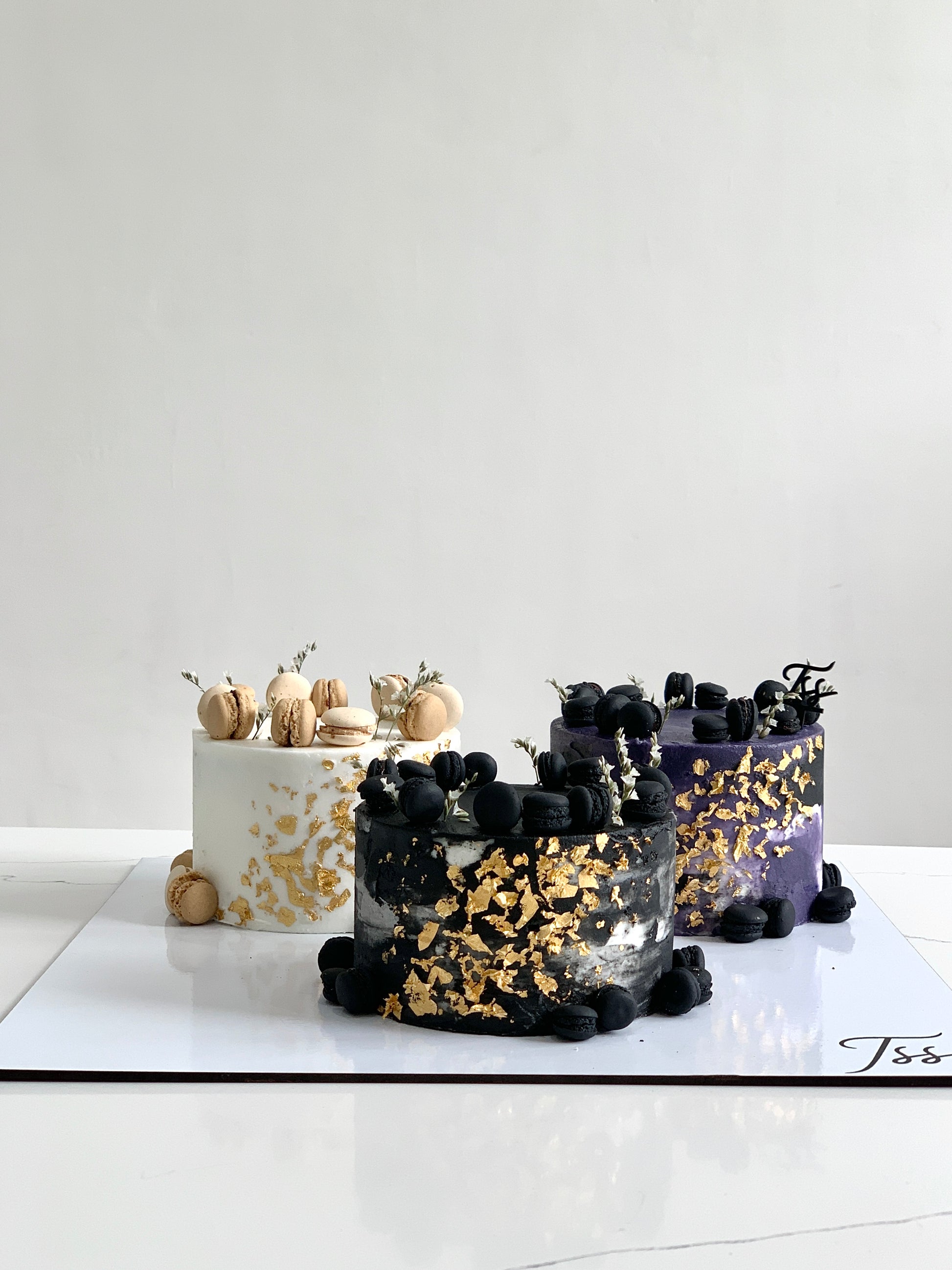 Assorted combo cakes from The Sinful Spoon featuring layered, colorful cakes with frosting and decorative toppings.