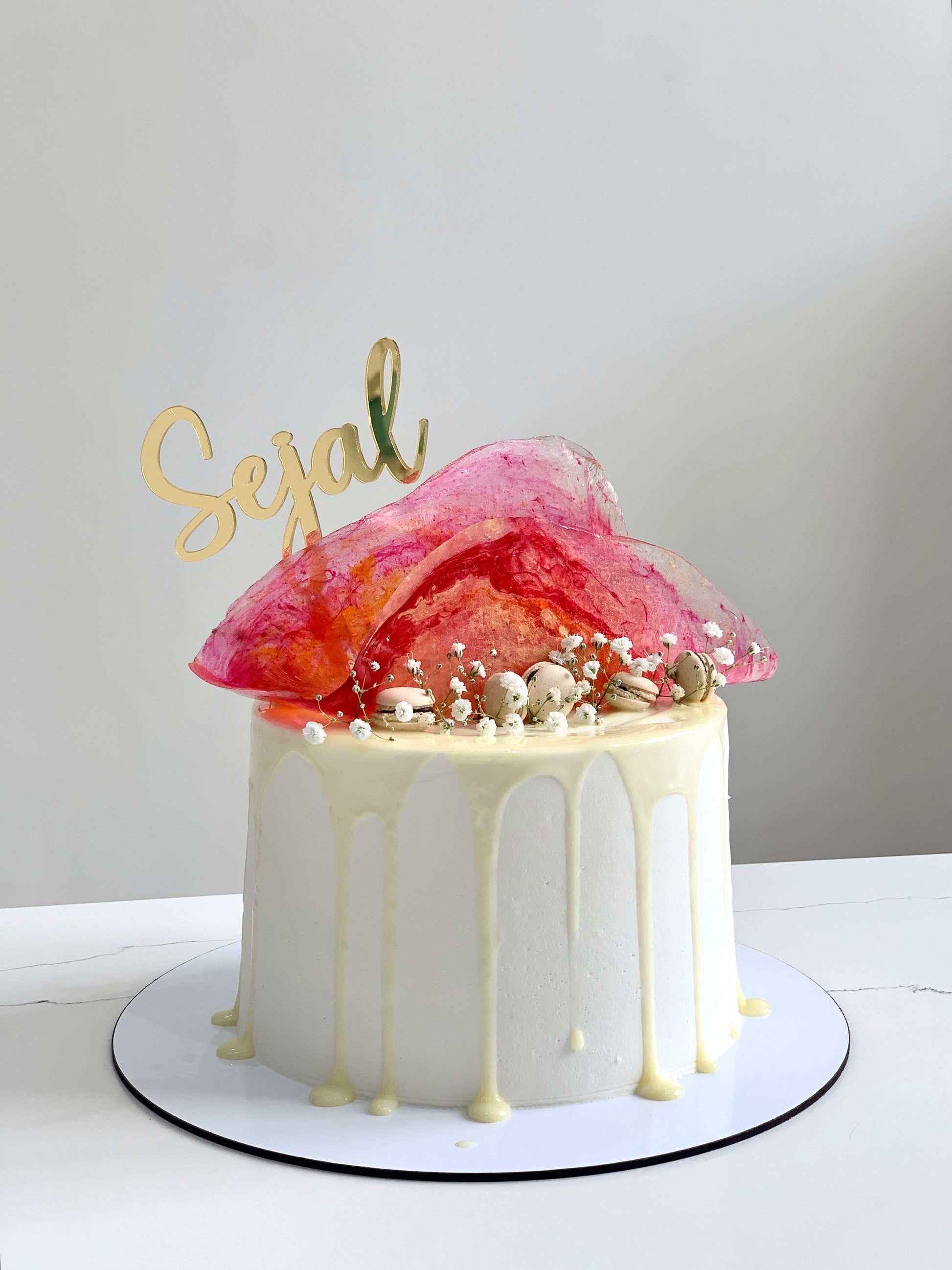 Colorful isomalt cakes from The Sinful Spoon arranged in a display, showcasing vibrant, shiny candy pieces for confectionery decoration.