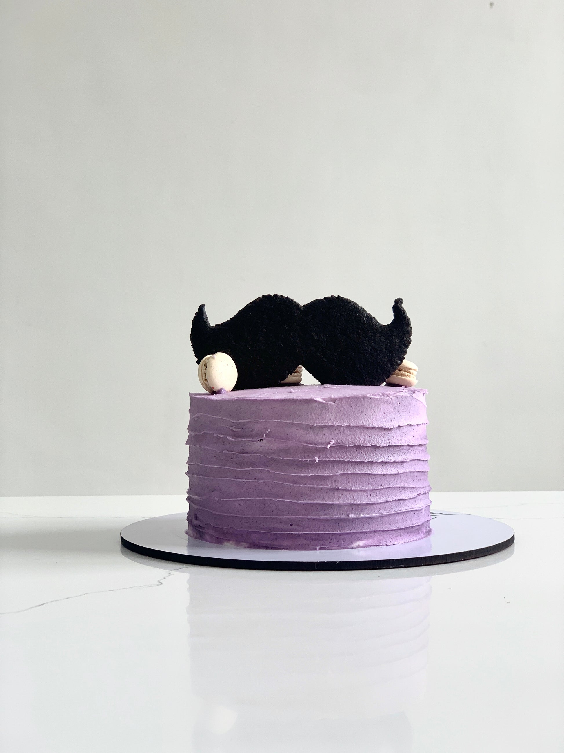 Decorative Father’s Day cake from The Sinful Spoon with colorful frosting and birthday candles, perfect for celebrating dads.