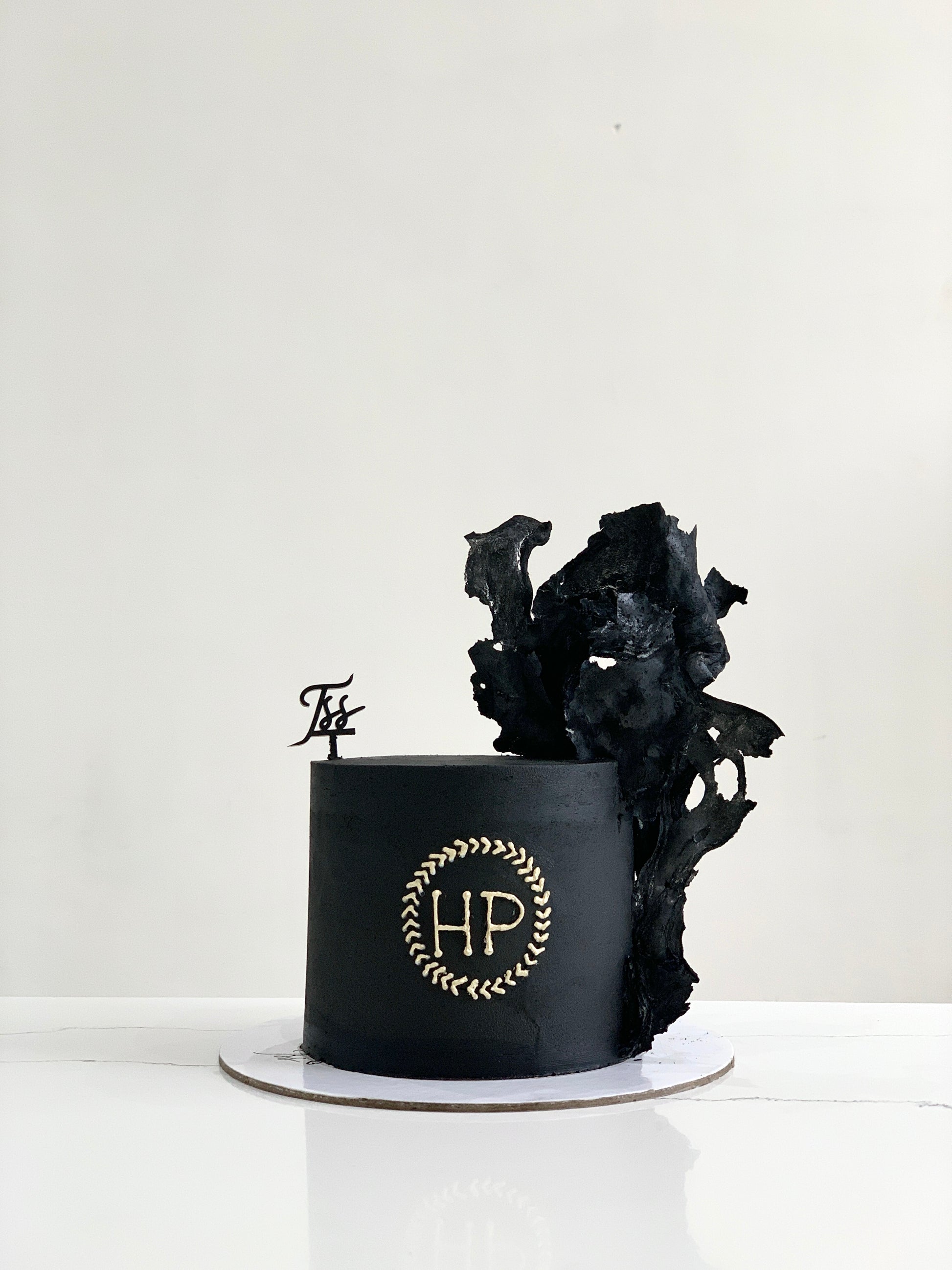 A classic cake from The Sinful Spoon with layered frosting and decorative toppings on a white plate.