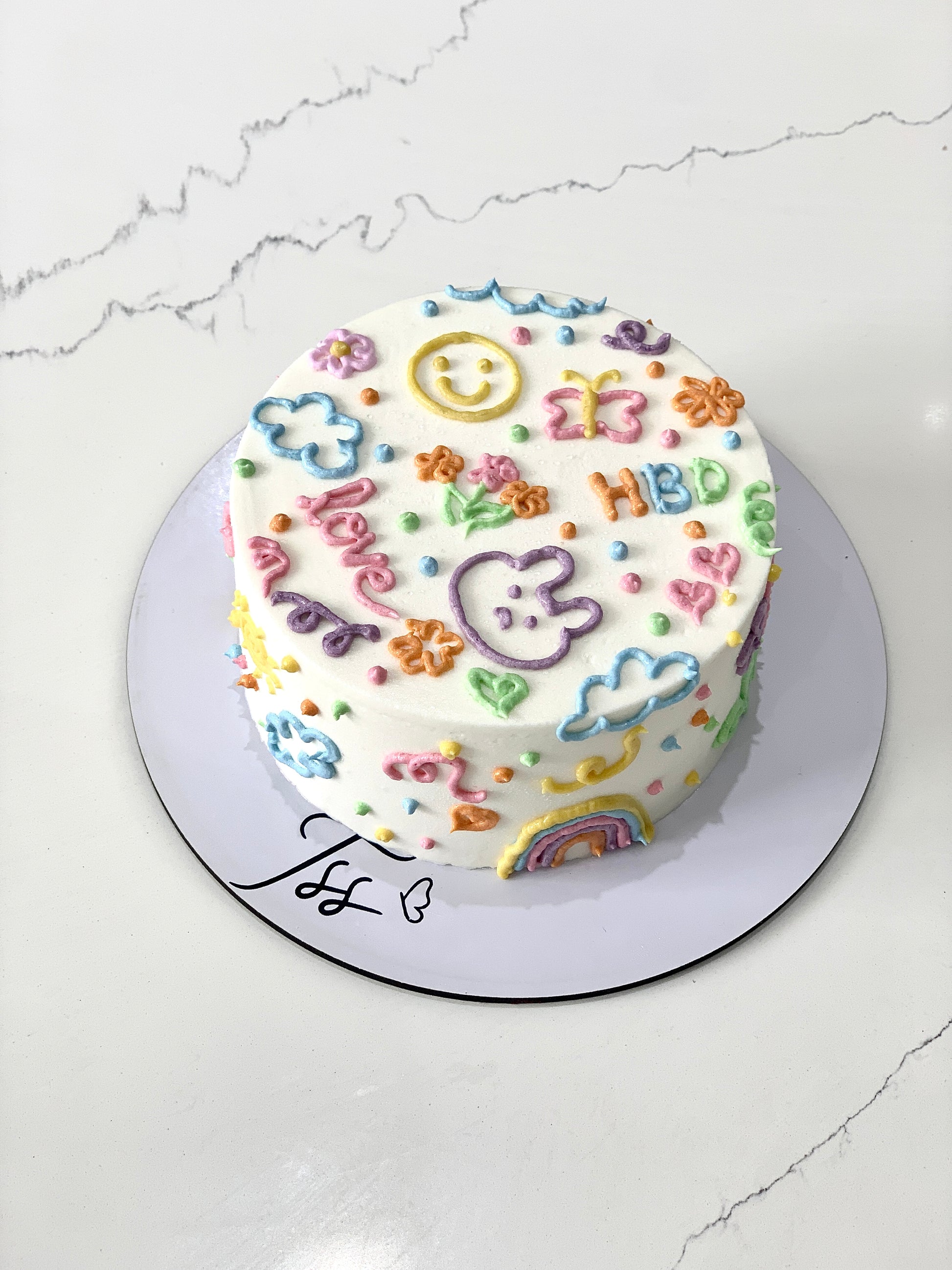 Colorful bento cakes from The Sinful Spoon with various vibrant, decorated cake slices arranged on a tray.