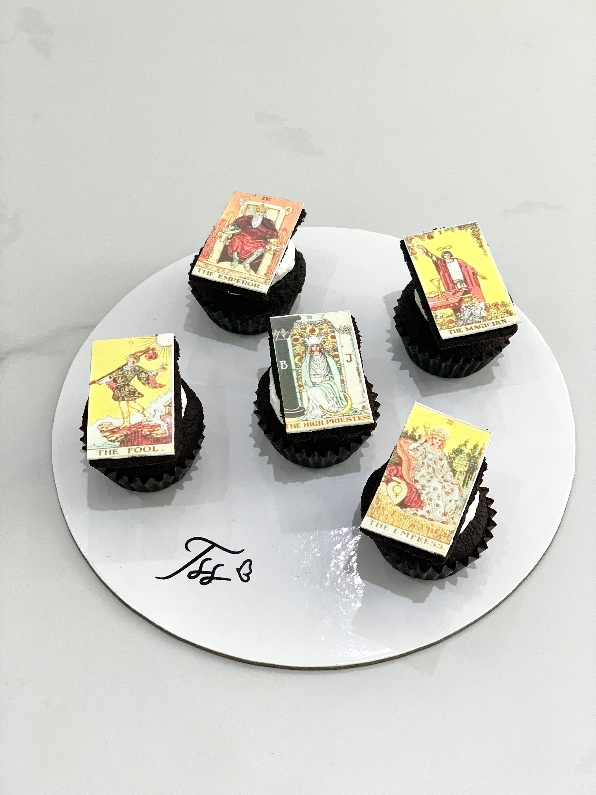 Delicious glazed cupcakes with colorful sprinkles from The Sinful Spoon, displayed on a white plate.