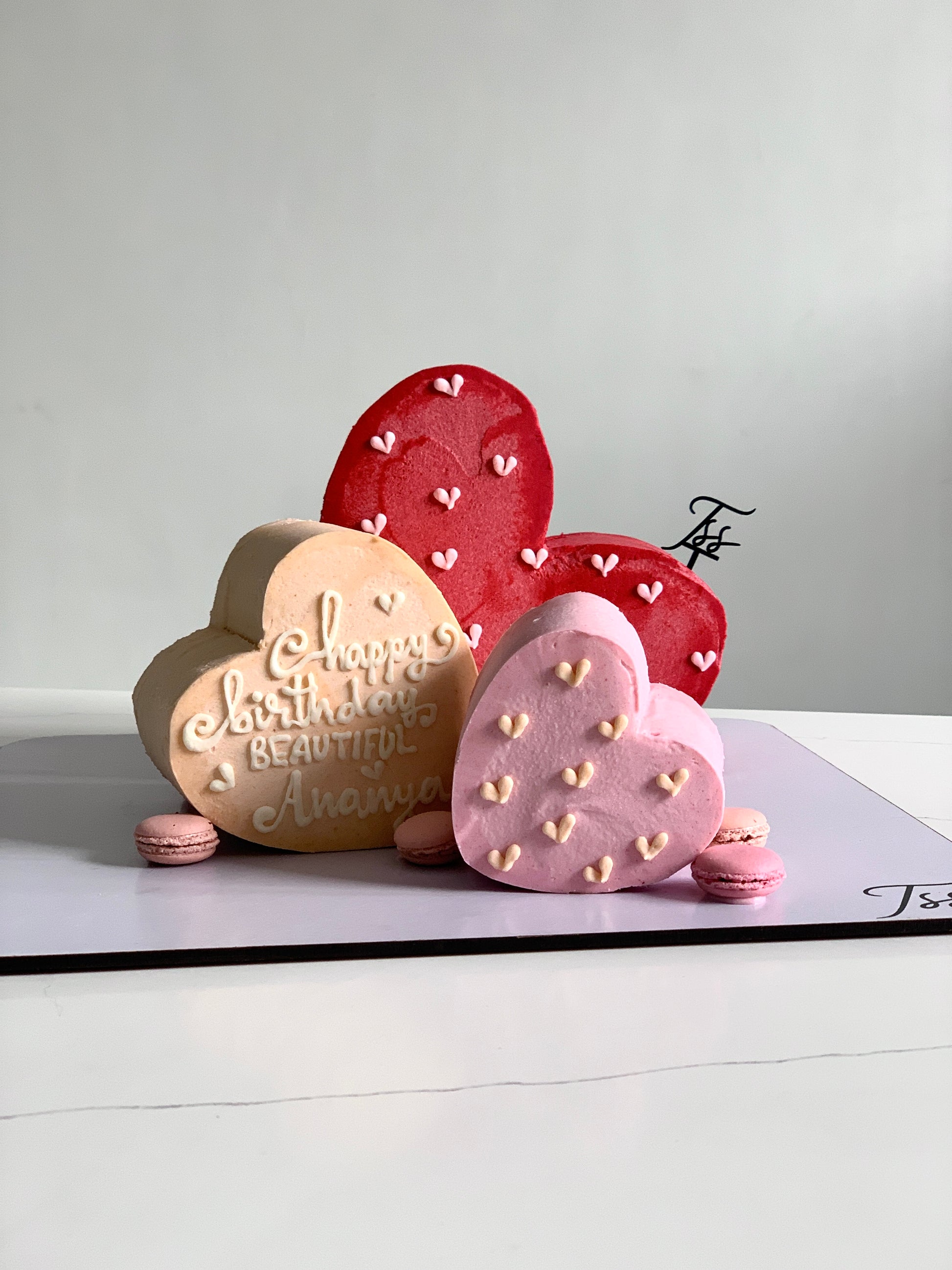 Heart-shaped cakes from The Sinful Spoon featuring creamy frosting and decorative sprinkles on a white plate.
