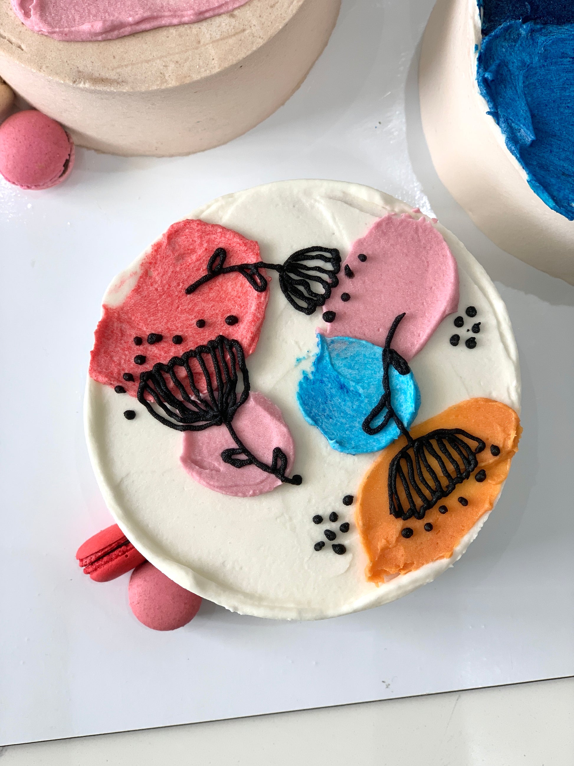 Decorative bento cakes from The Sinful Spoon featuring colorful frosting and creative designs on individual cake slices.