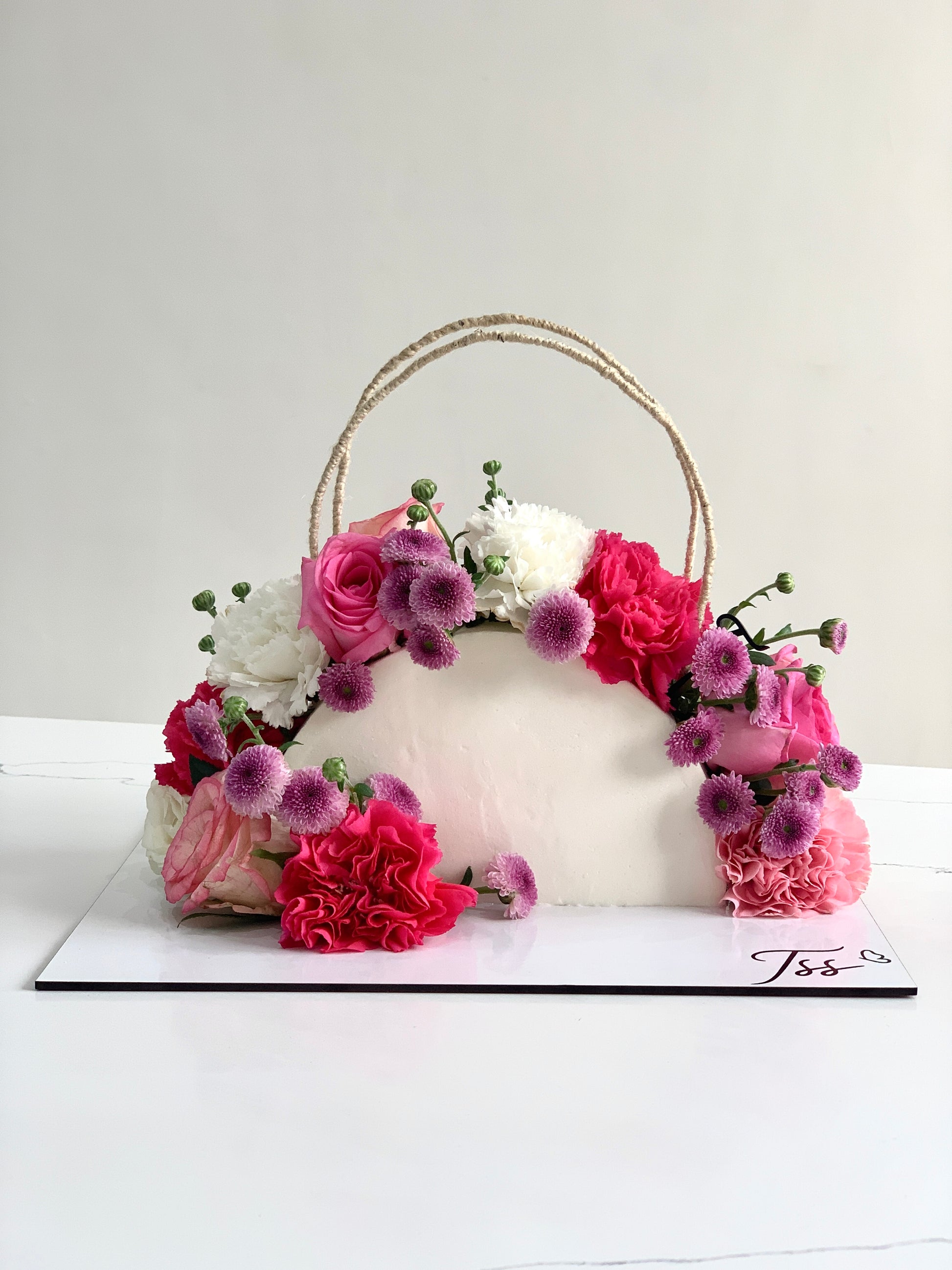 Fresh floral cakes from The Sinful Spoon decorated with colorful edible flowers and intricate piping designs.