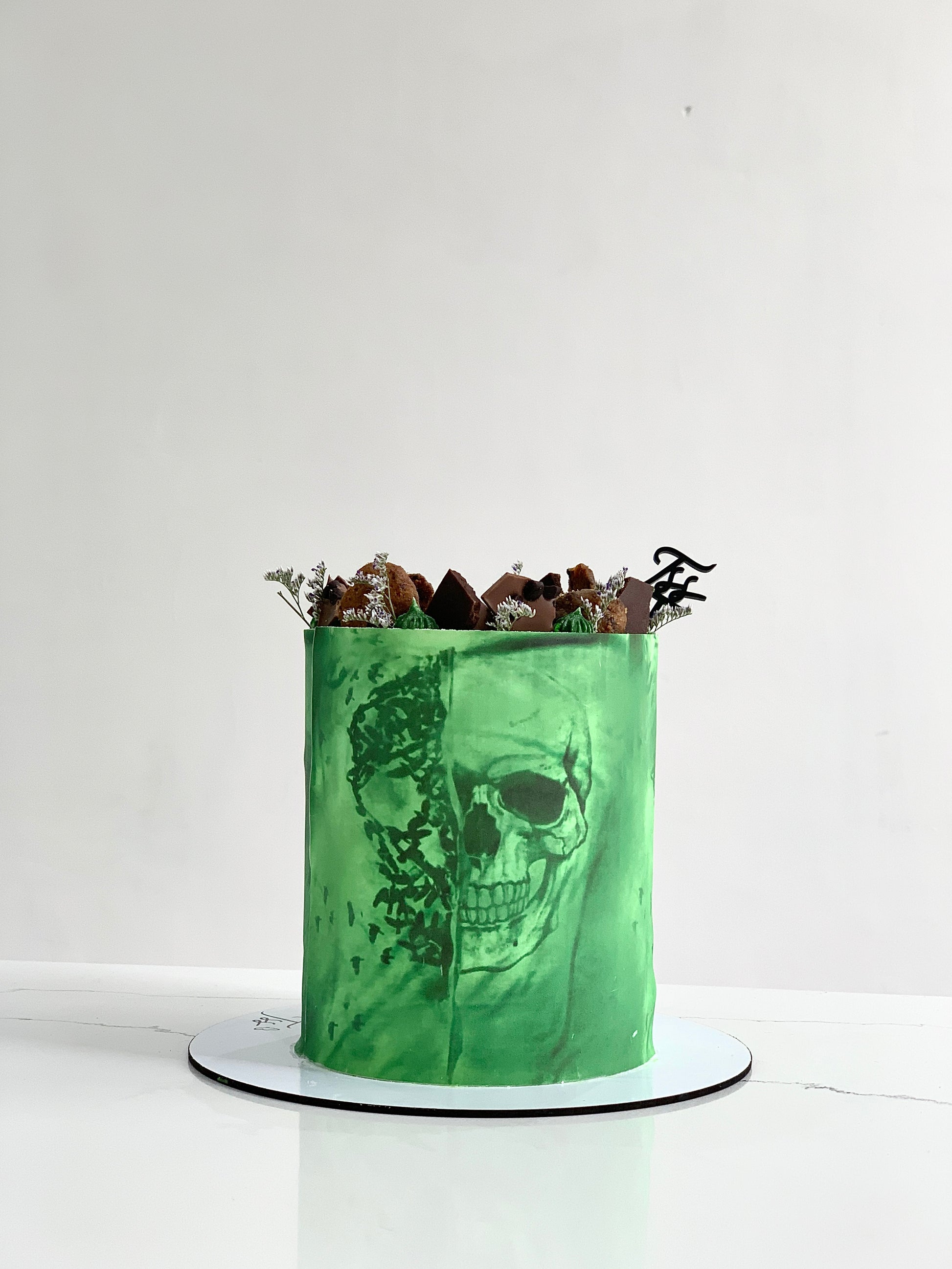 Edible paper cake with colorful floral design, created by The Sinful Spoon, showcasing intricate edible decoration on a cake.