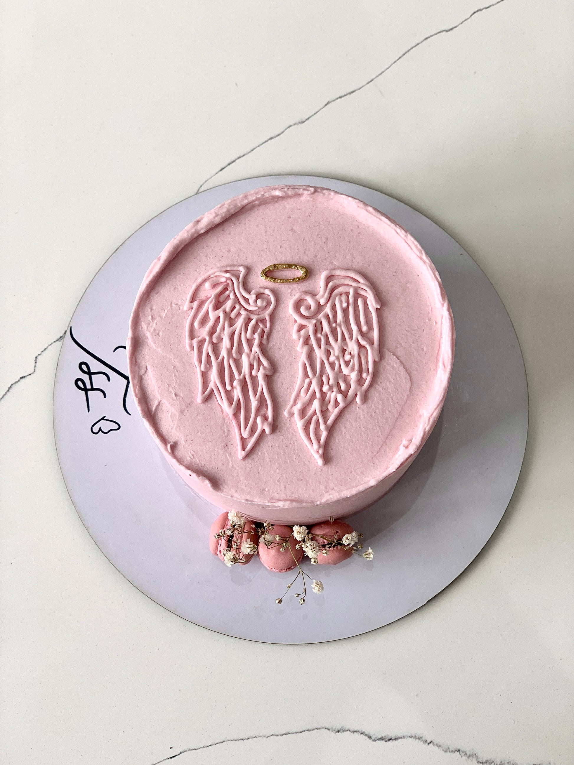Decorative baby shower cake with pastel frosting and baby-themed toppers from The Sinful Spoon.
