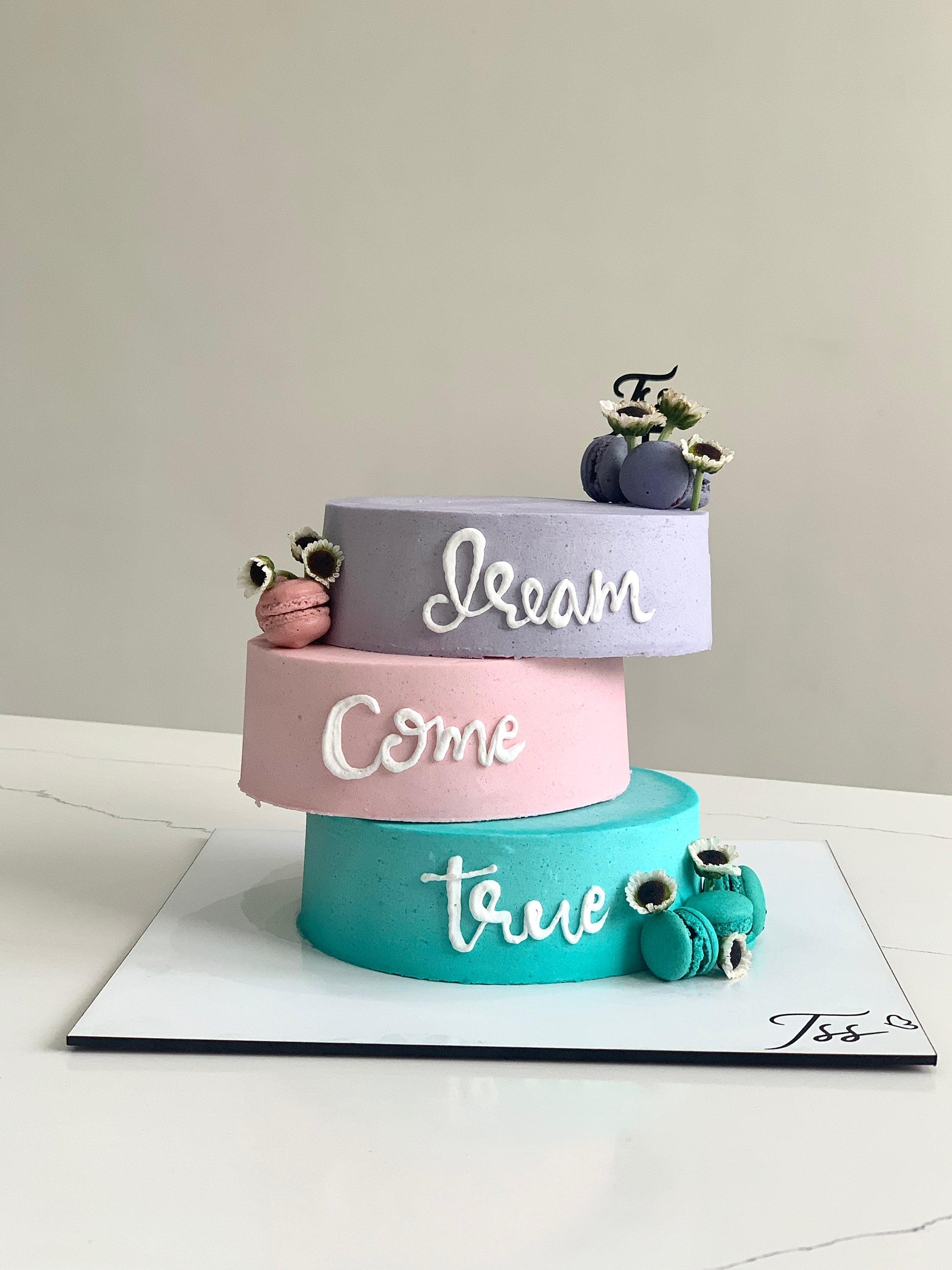 Asymmetrical cakes from The Sinful Spoon with layered, creative designs displayed on a cake stand.