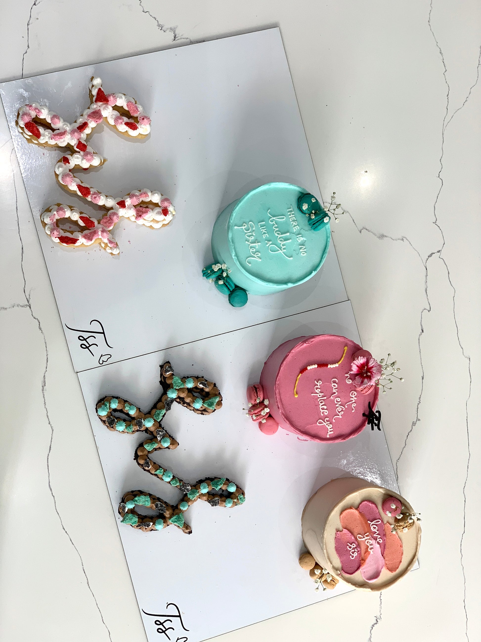 Decorative festive cakes from The Sinful Spoon featuring colorful icing and holiday-themed designs on a white background.