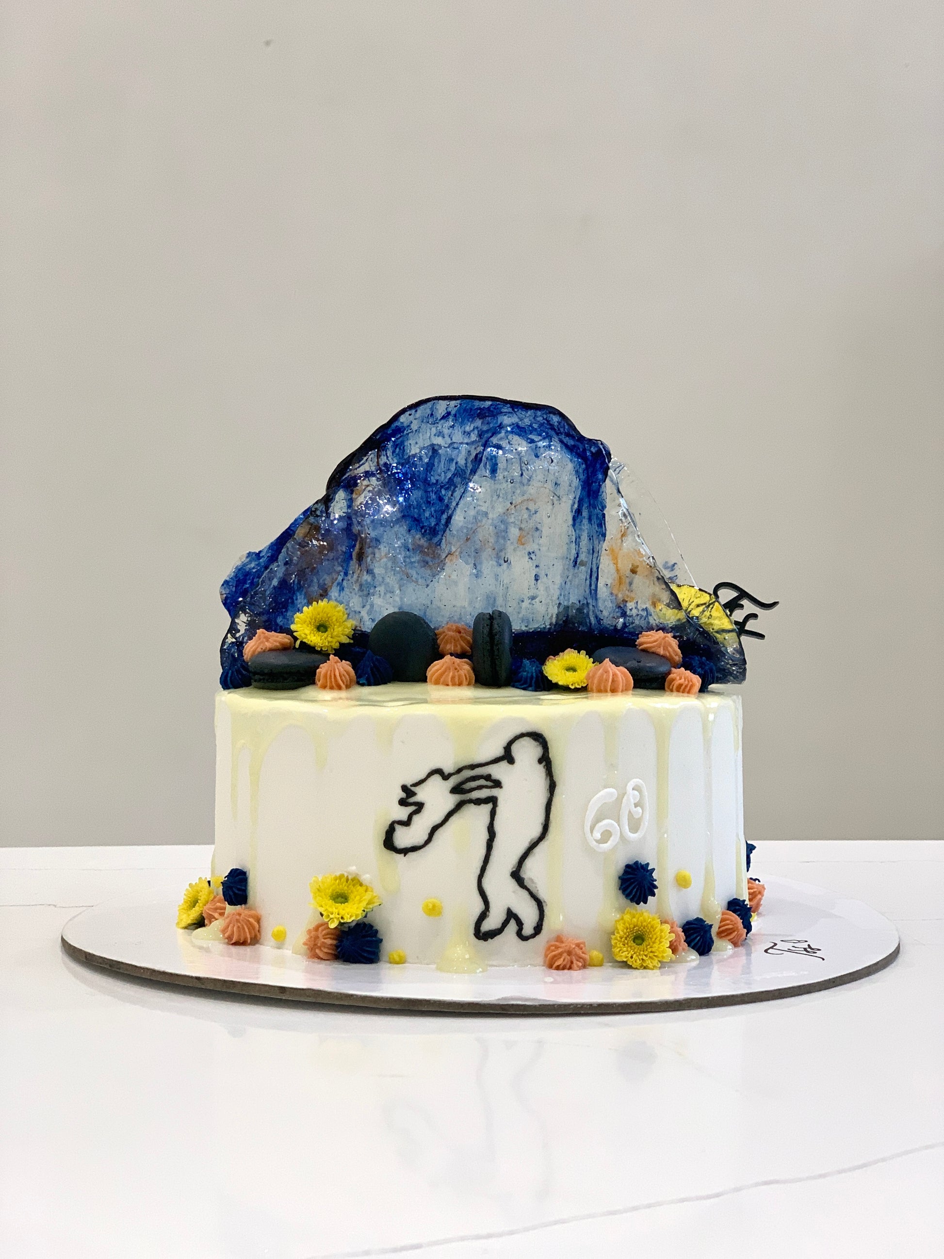 Decorative Father’s Day cake from The Sinful Spoon featuring colorful frosting and festive design with whipped cream and sprinkles.