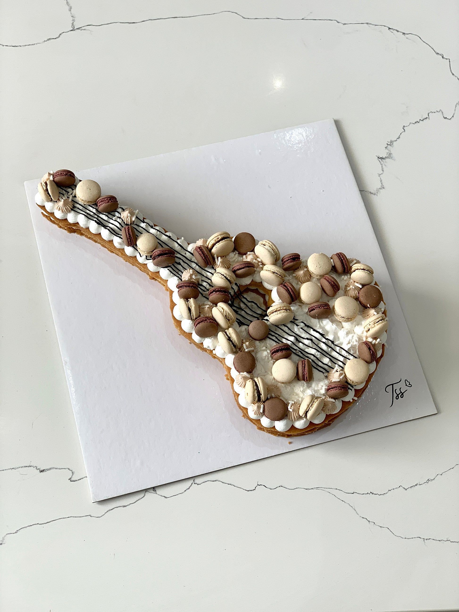 Decorative Cookie Cakes from The Sinful Spoon with colorful frosting and intricate designs on a white plate.