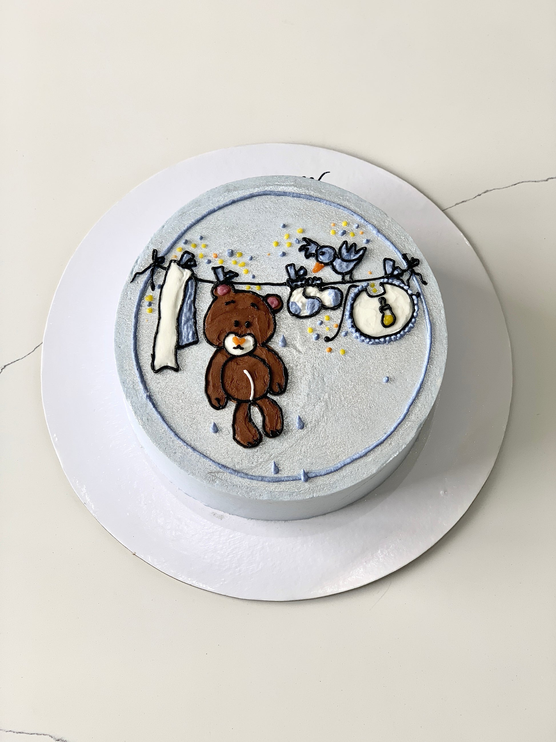 Decorative baby shower cake from The Sinful Spoon with pastel colors, adorable baby-themed decorations, and intricate piping details.