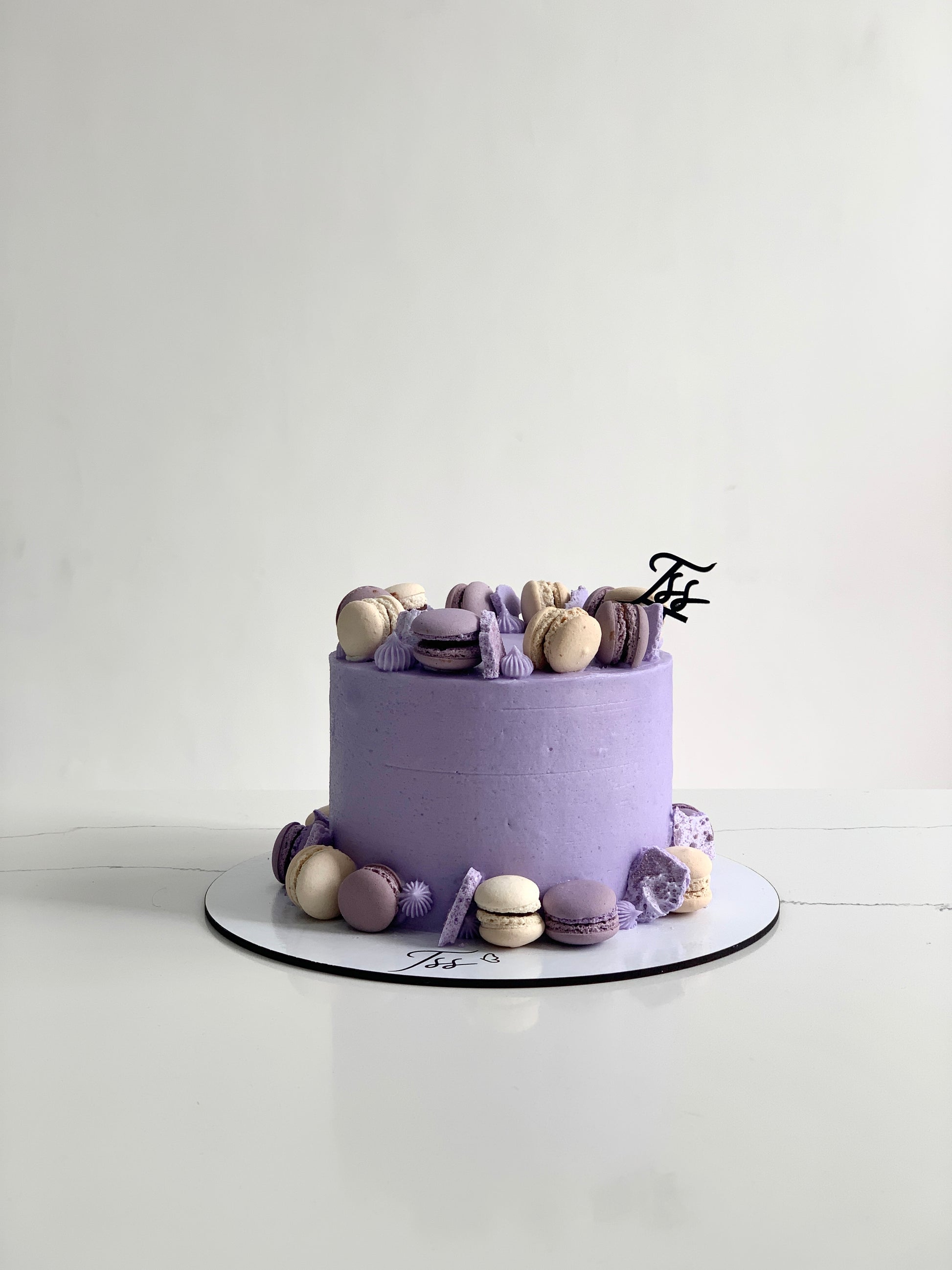 A Classic Cakes dessert from The Sinful Spoon with rich frosting and decorative toppings, displayed on a white plate.