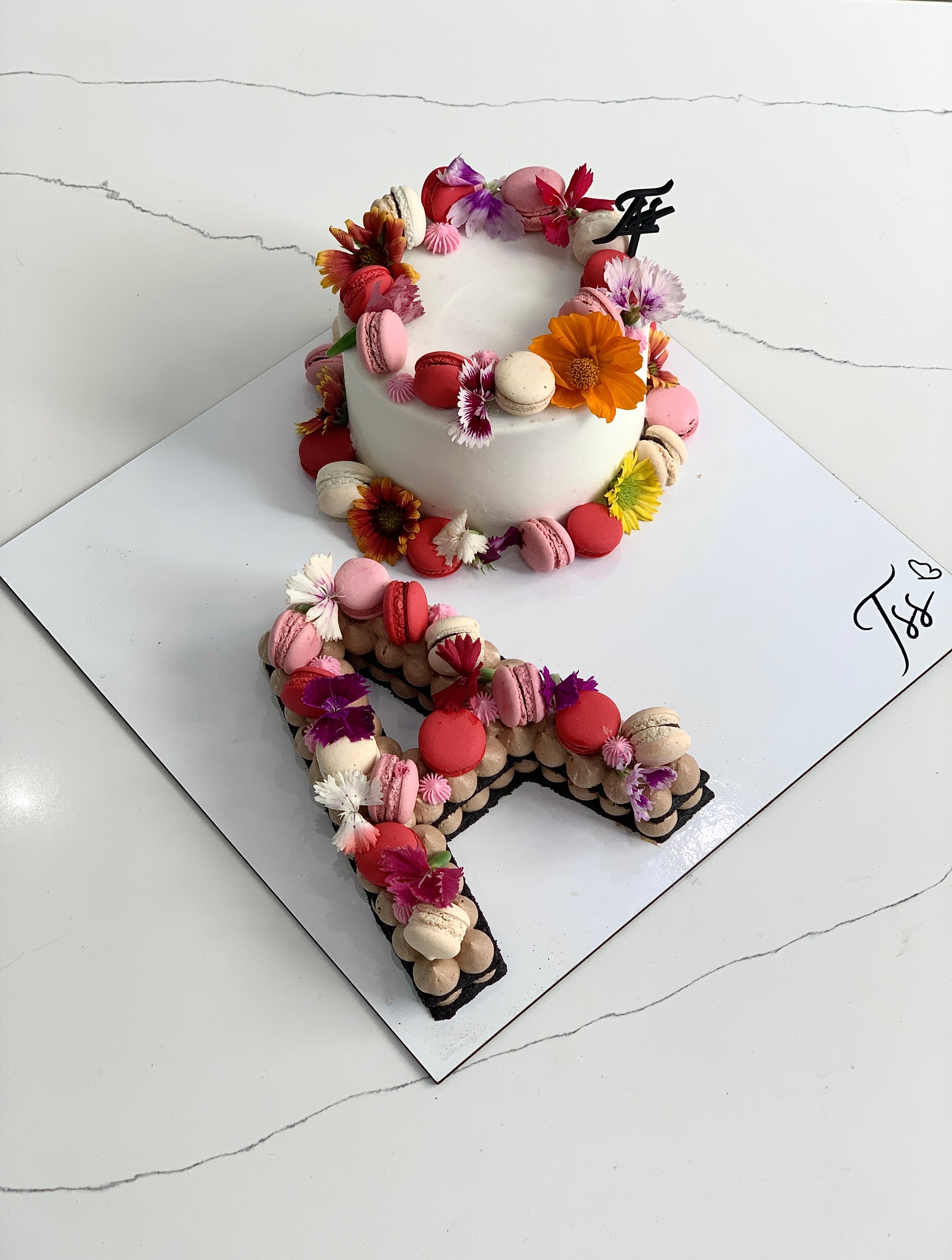 Assorted combo cakes from The Sinful Spoon, featuring layered desserts with colorful frosting and decorative toppings.