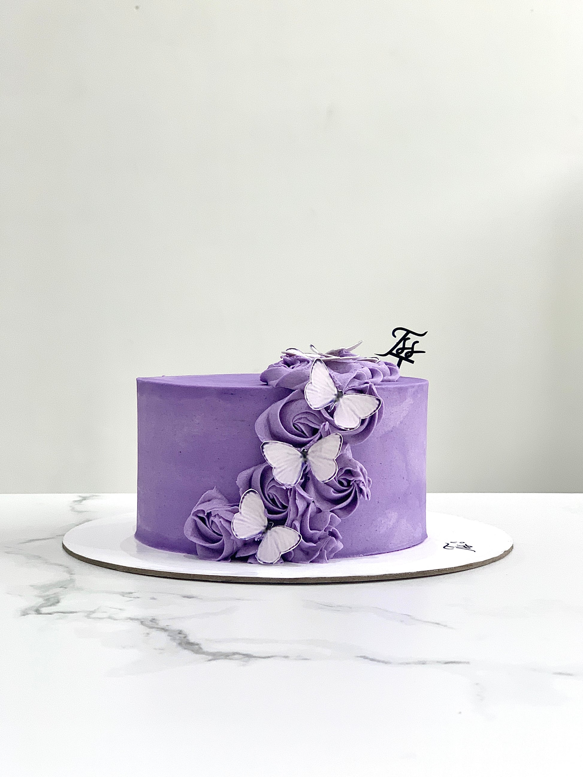 Edible paper cake topper for baby girl celebration by The Sinful Spoon, featuring colorful floral and baby-themed decorations.