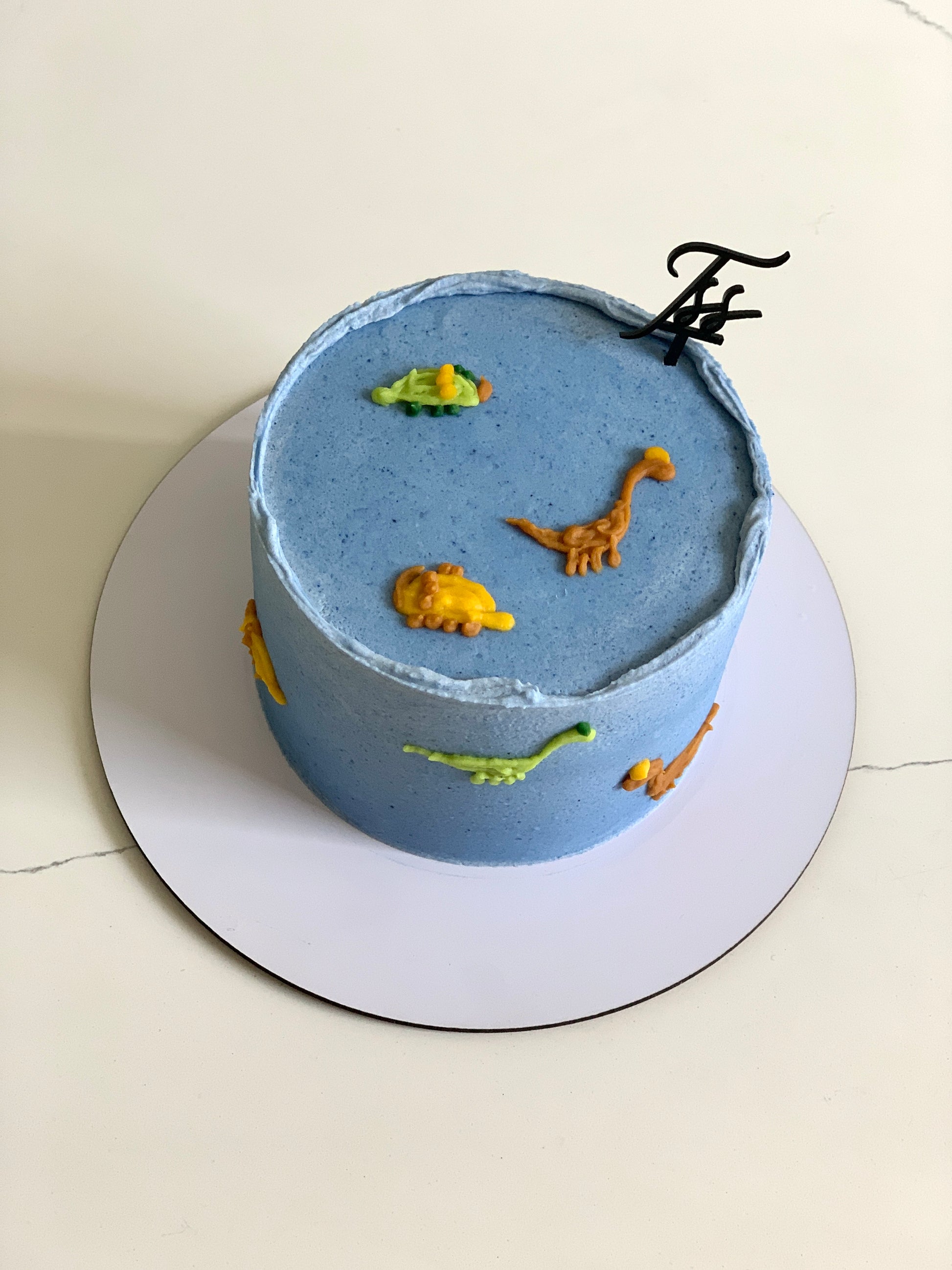 Decorative buttercream illustration cake by The Sinful Spoon featuring colorful floral and artistic piping details.