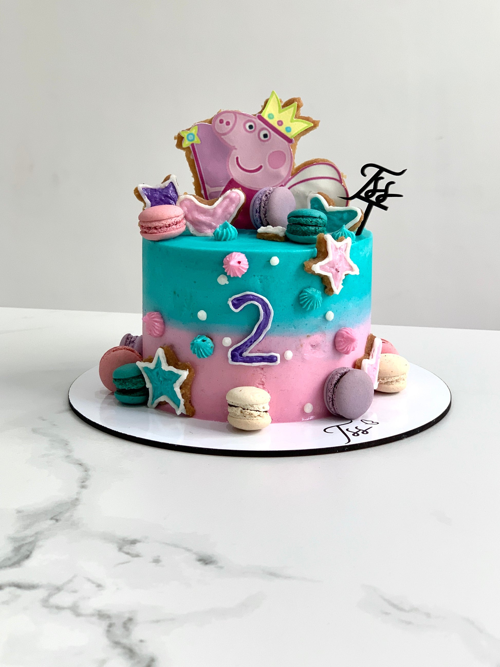 Edible paper cake topper for baby girl celebration by The Sinful Spoon, featuring colorful baby-themed design on a cake.