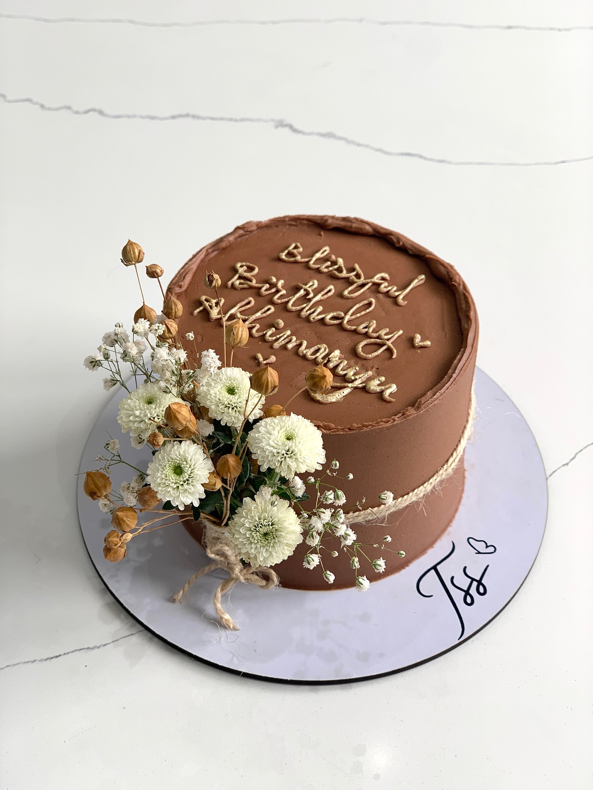 Decorative fresh floral cake from The Sinful Spoon with colorful edible flowers and intricate frosting details.