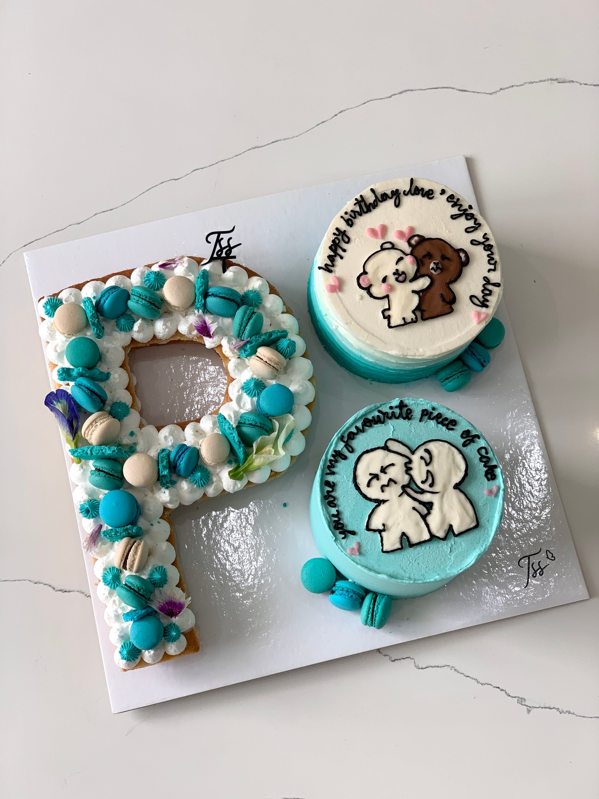 Assorted combo cakes from The Sinful Spoon featuring colorful, layered desserts with frosting and toppings on a white plate.