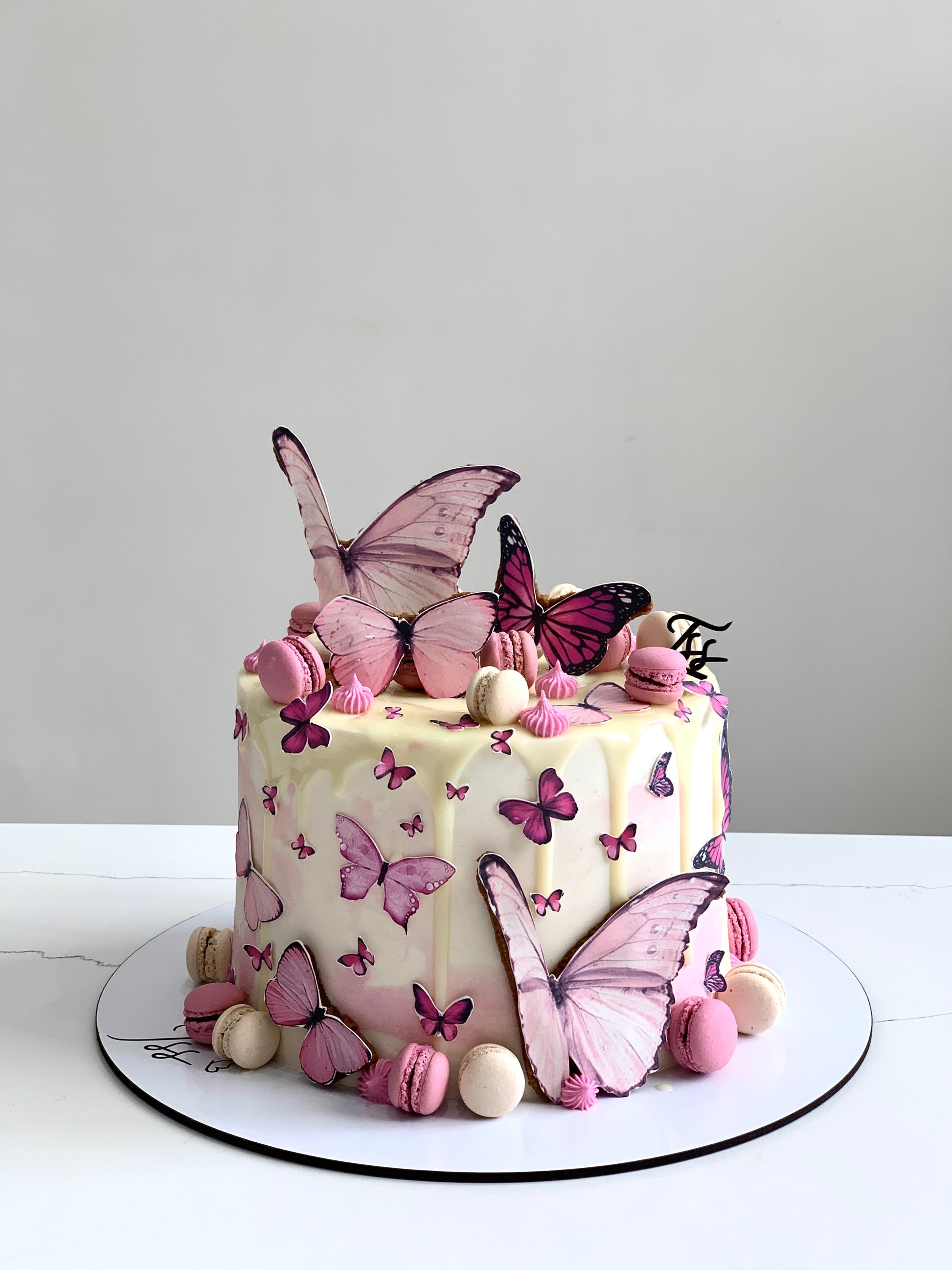 Edible paper cake topper for baby girl celebration by The Sinful Spoon, featuring delicate pink and white design.