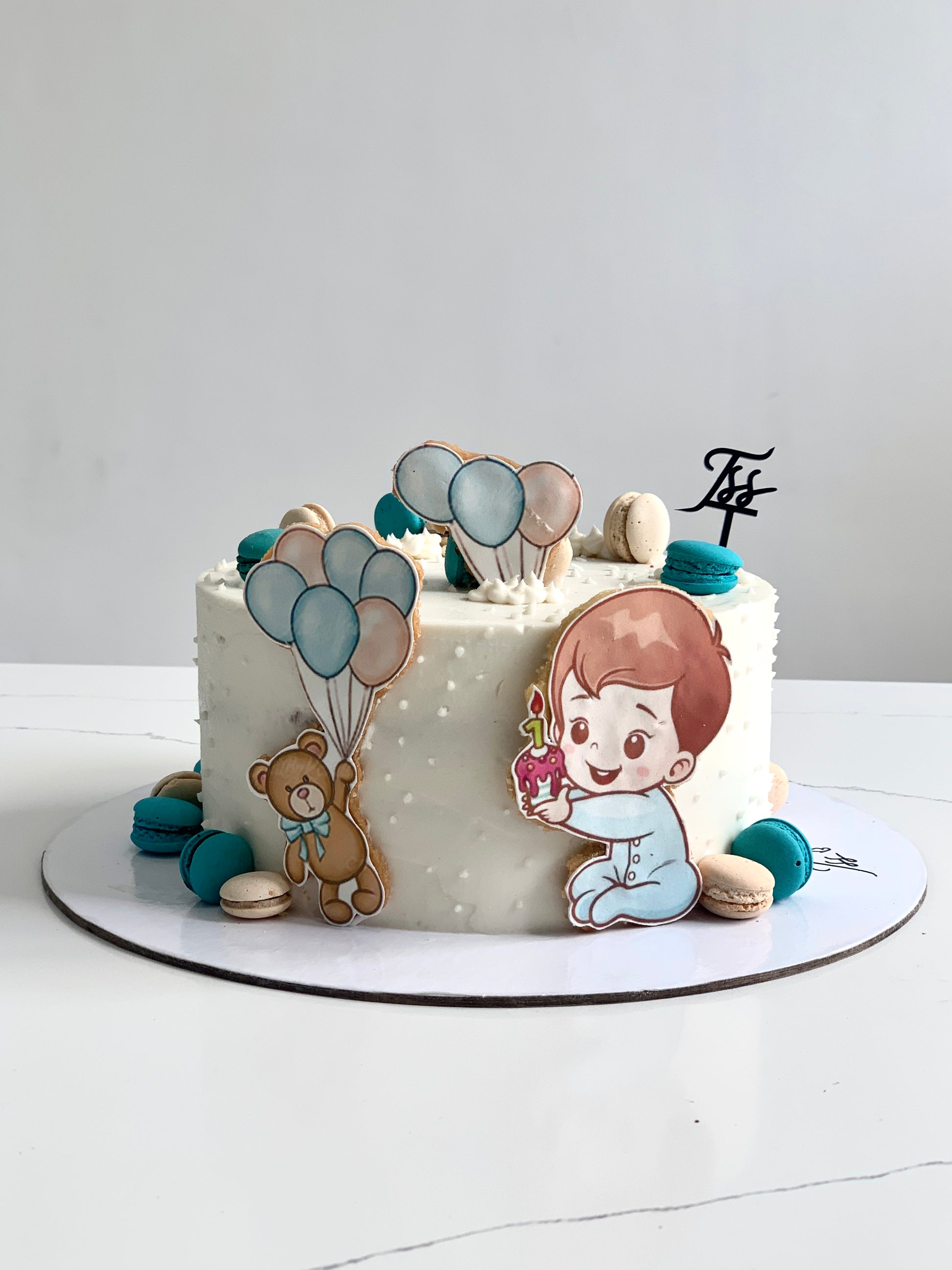 Decorative baby shower cake with pastel colors and cute baby-themed designs from The Sinful Spoon.