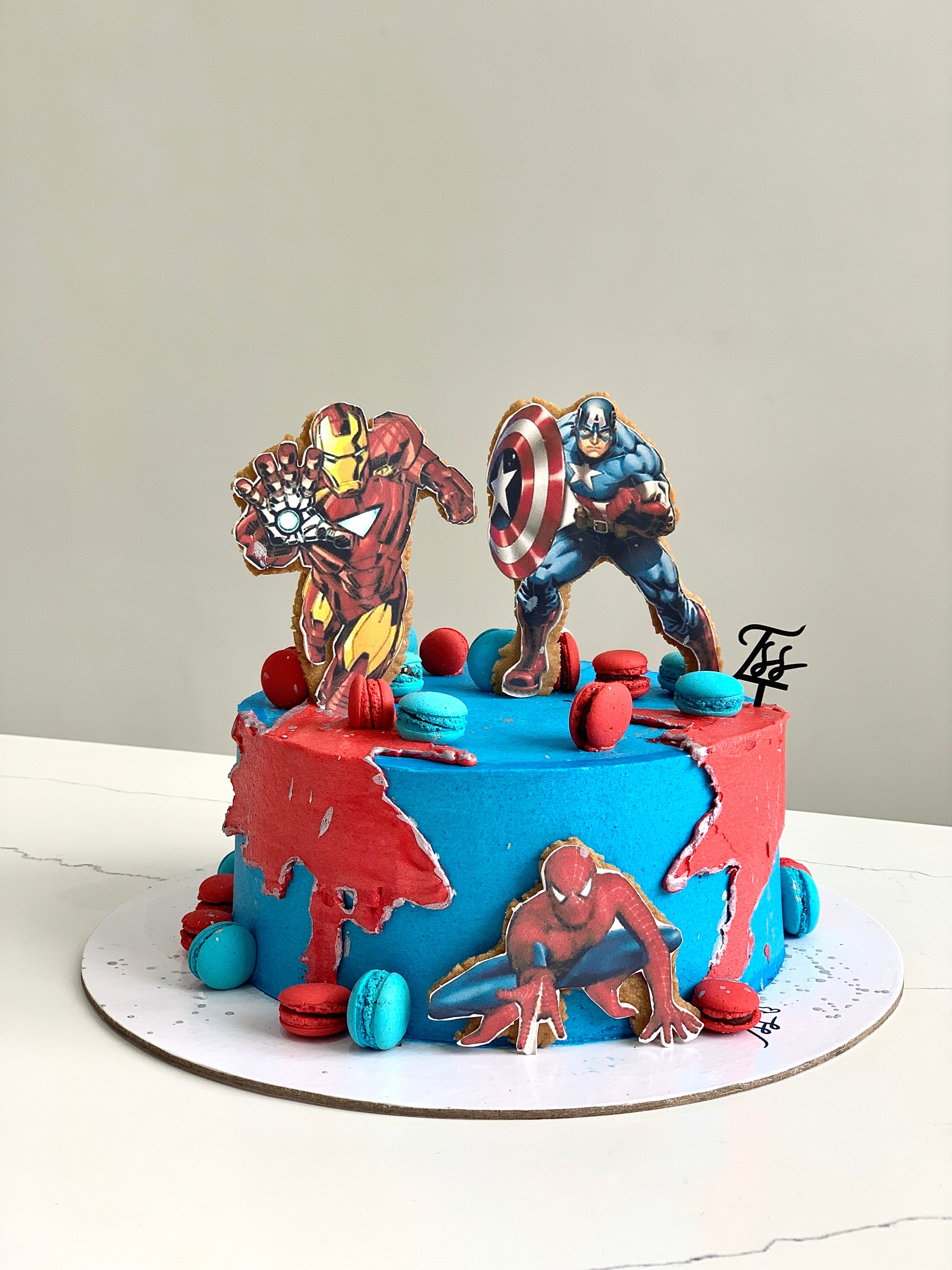Edible paper cake with baby boy design by The Sinful Spoon, featuring colorful decorative elements on a cake.