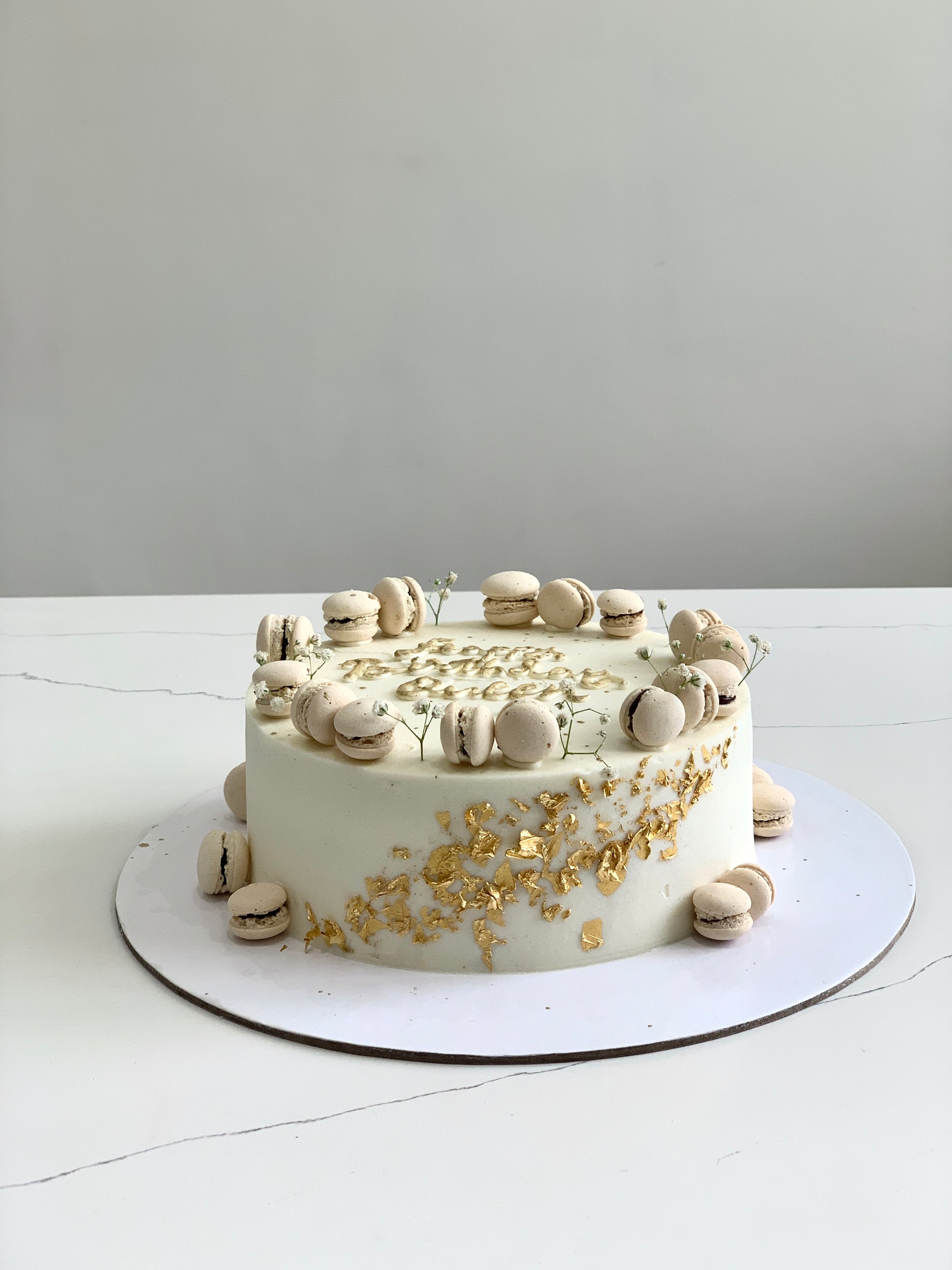 Slice of classic layered cake from The Sinful Spoon featuring creamy frosting and colorful sprinkles on top.