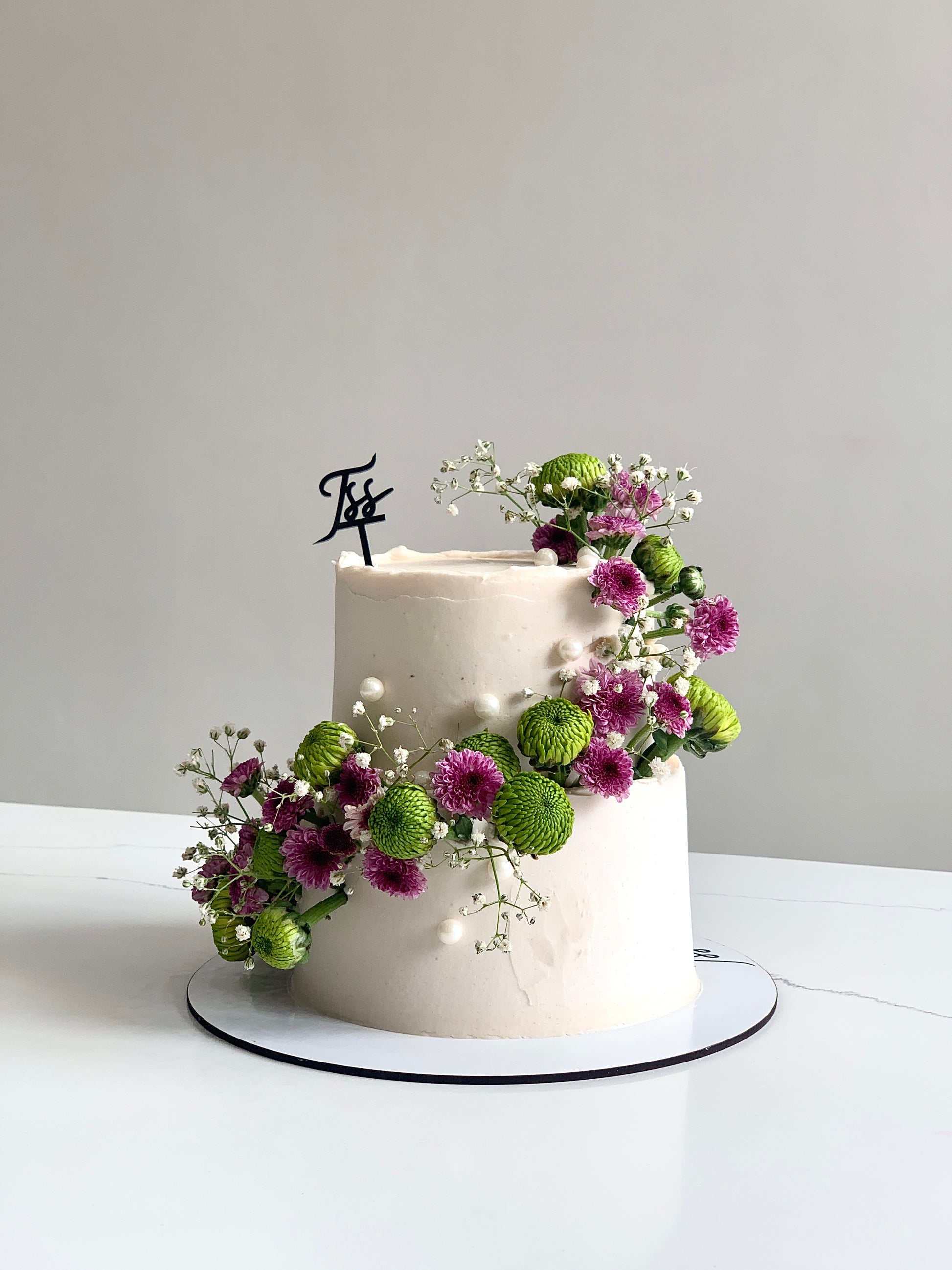 Miniature tier cakes from The Sinful Spoon, featuring colorful frosting and decorative toppings, perfect for celebrations.